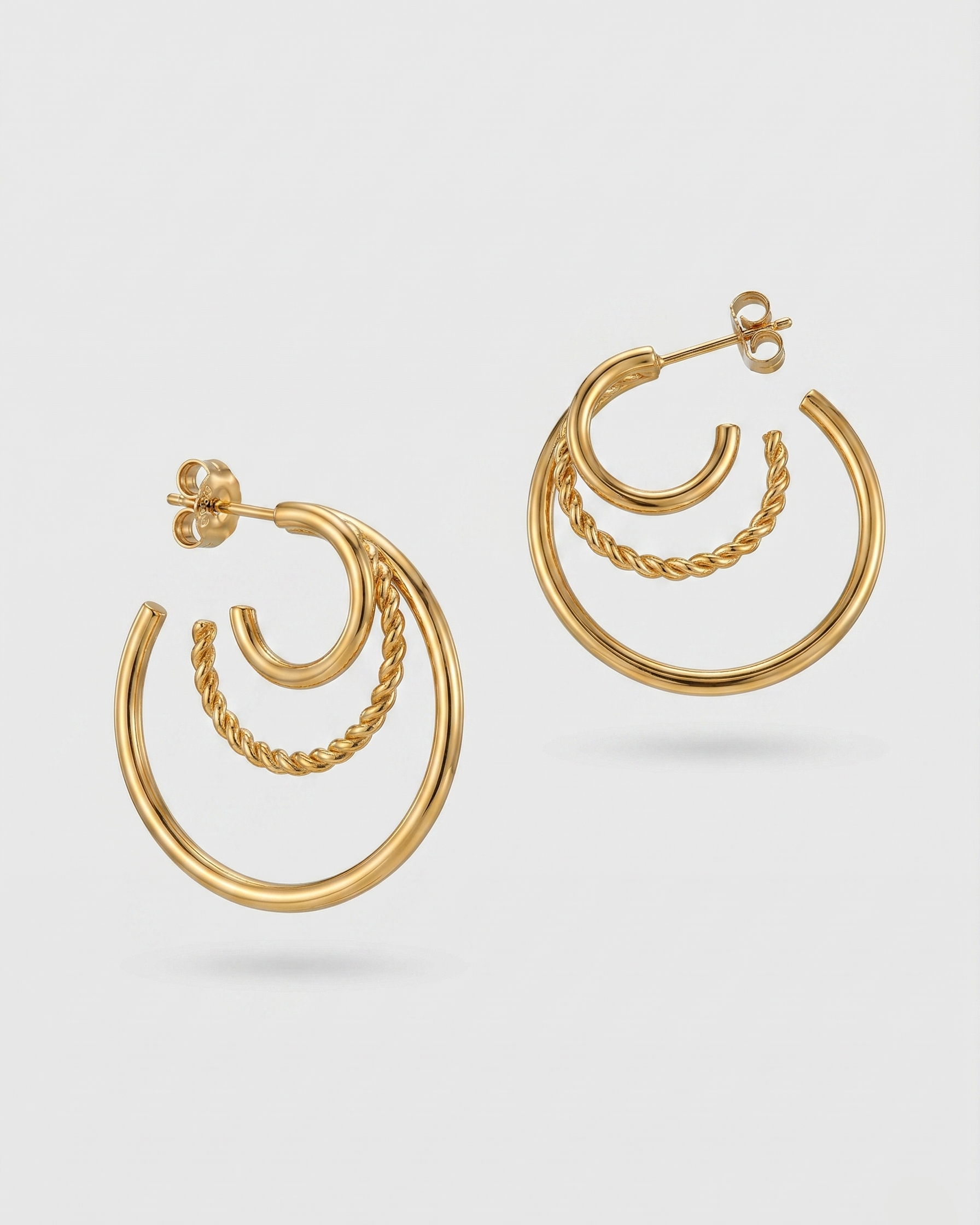 Gold hoop earrings on a light gray background
