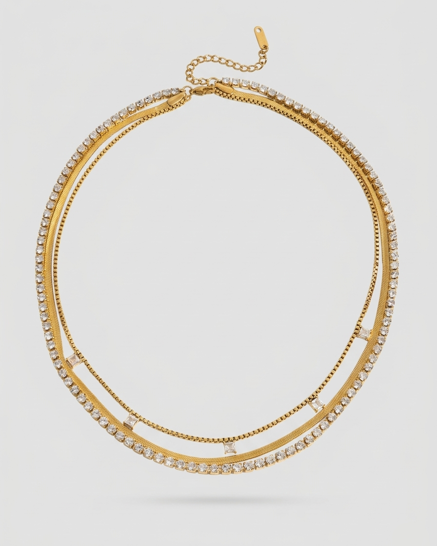 Gold necklace with clear stones on a light gray background