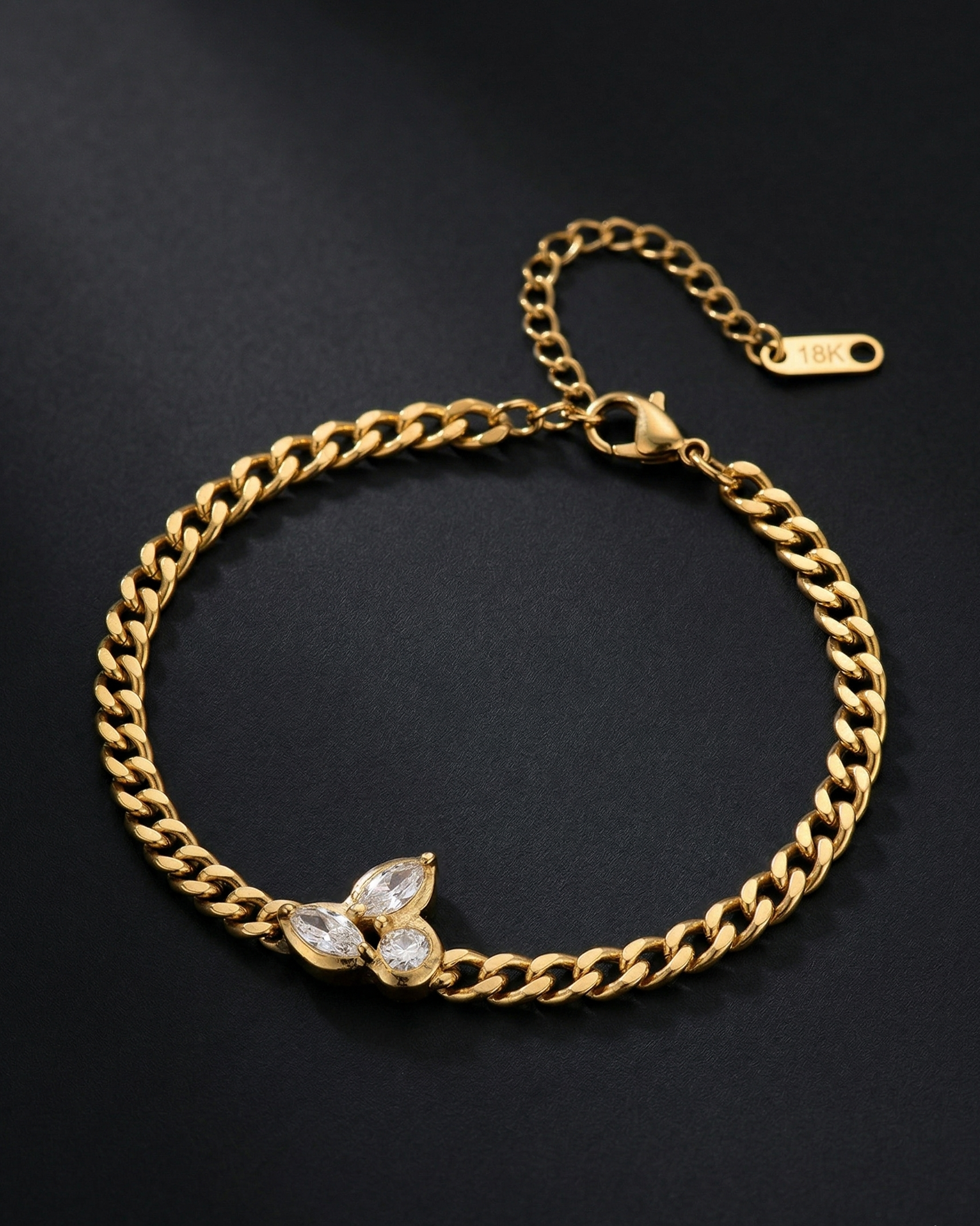 Gold chain bracelet with a butterfly charm on a black background
