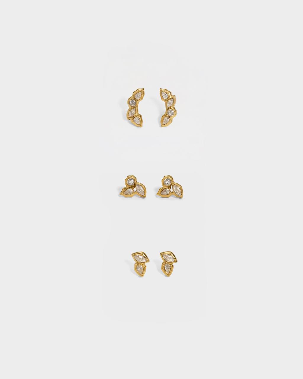 Set of gold earrings on a light gray background