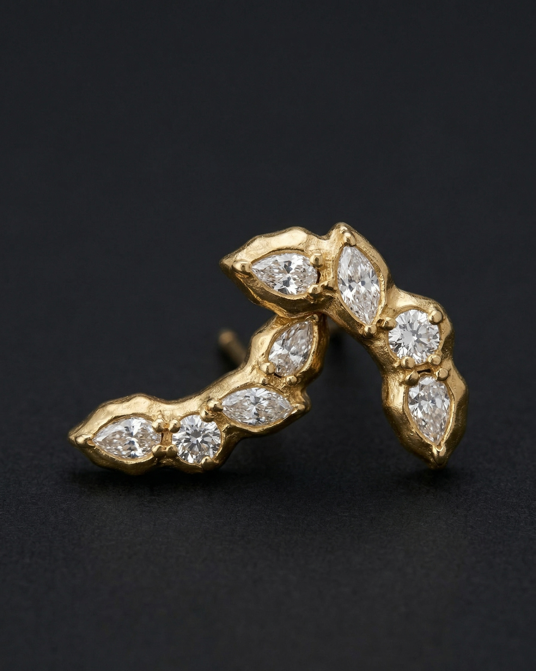 Gold earring with diamond stones on a black background