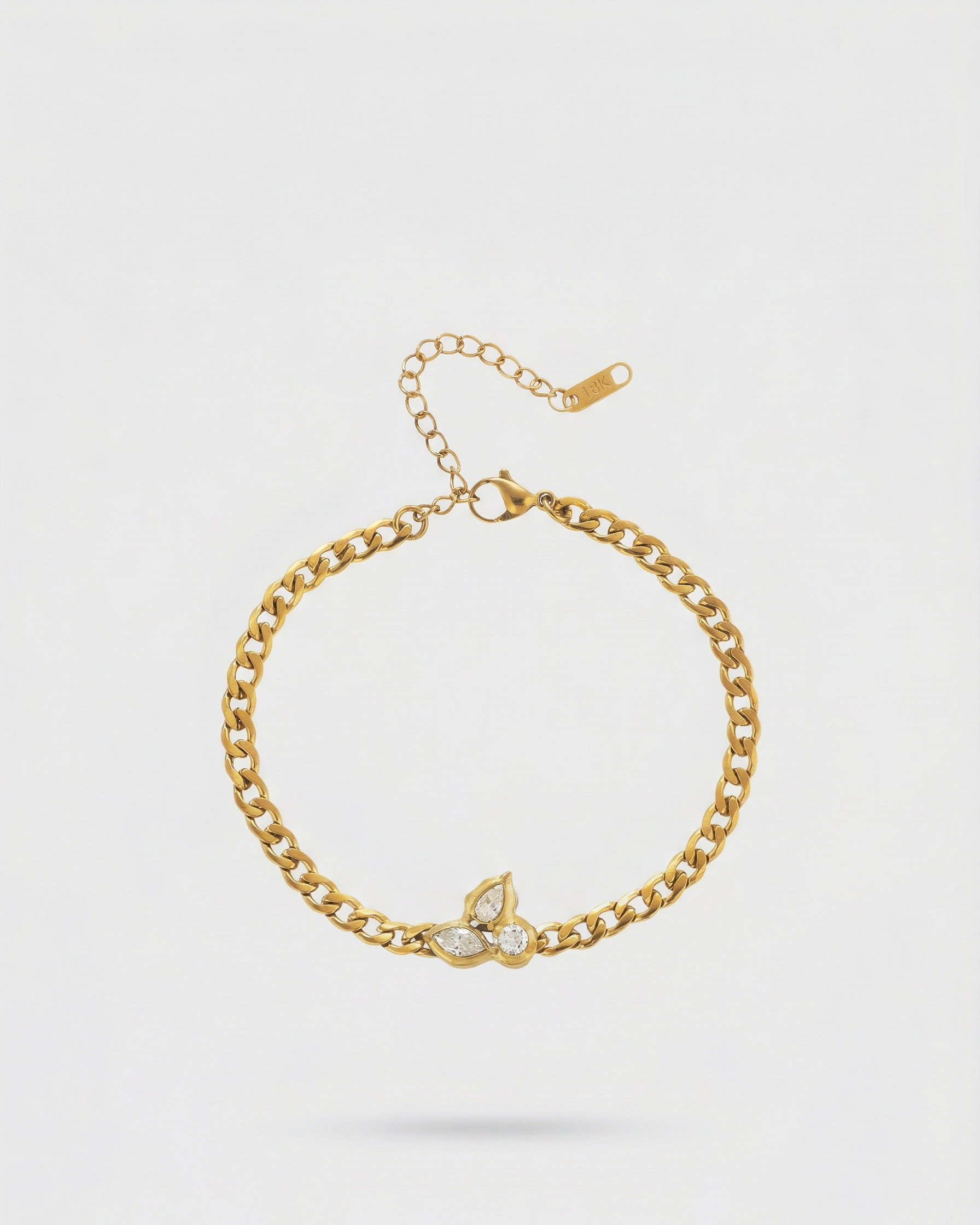 Gold bracelet with a butterfly charm on a light gray background