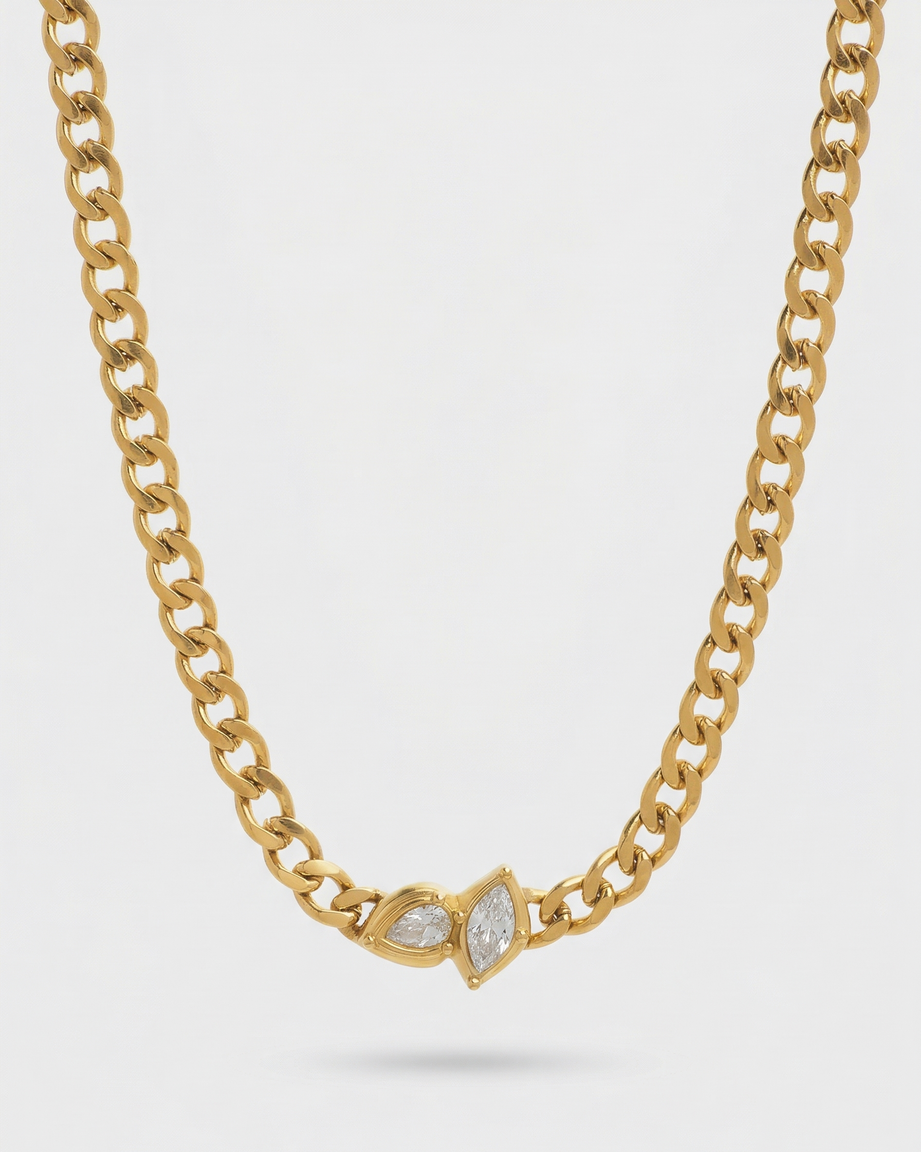 Gold chain necklace with marquise-shaped gemstones on a light gray background