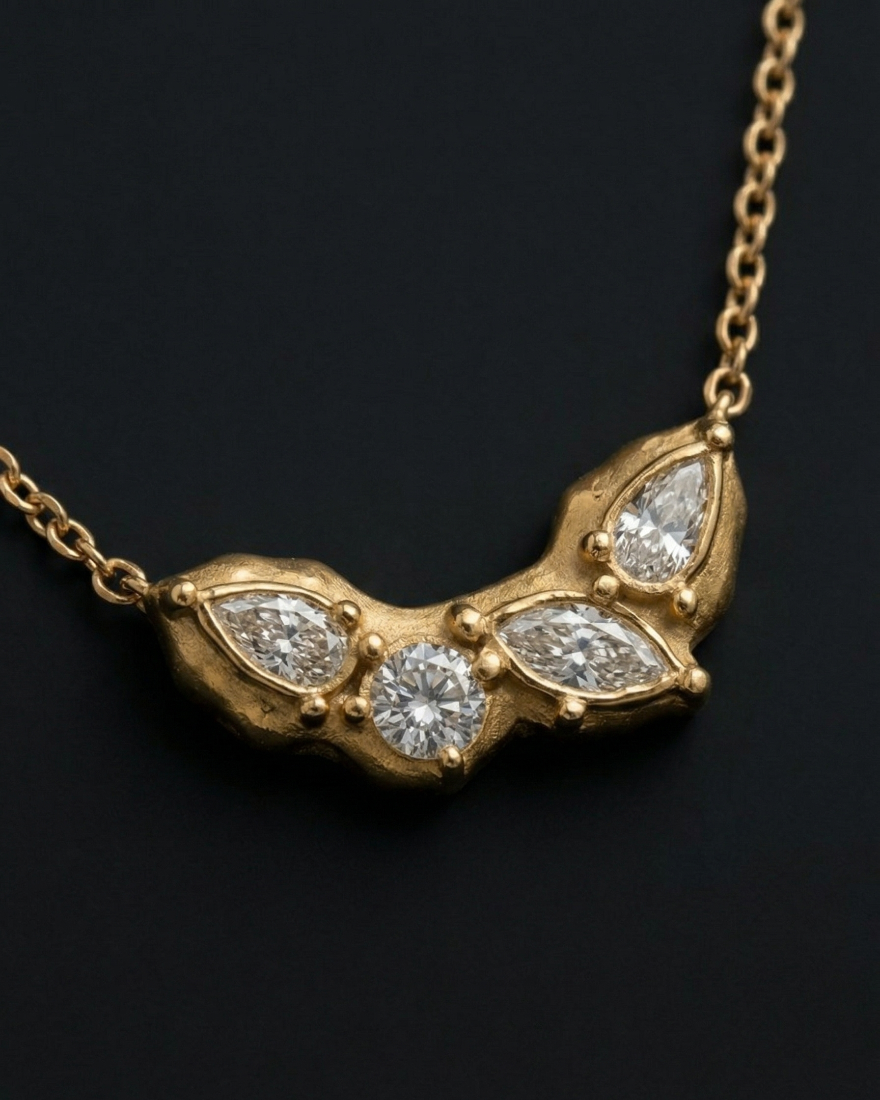 Gold necklace with diamond pendants on a black background