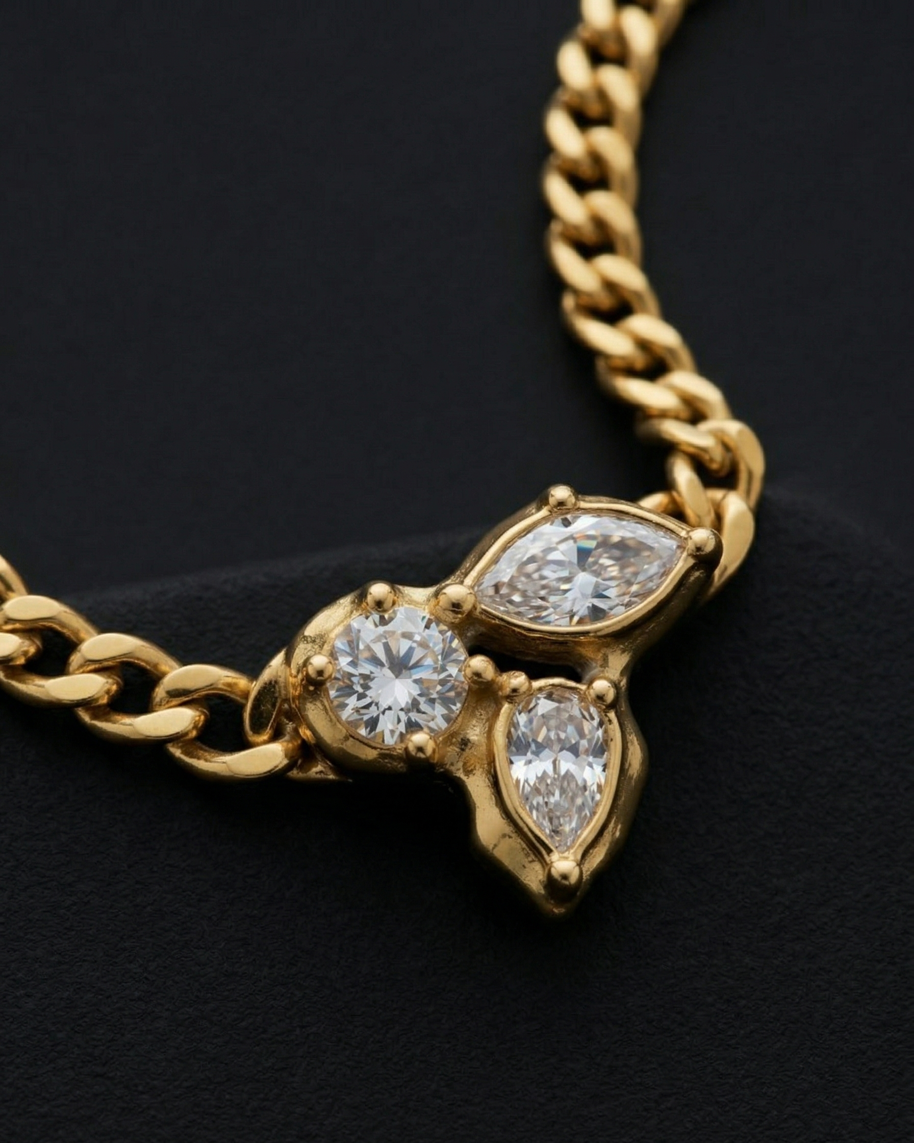 Gold chain necklace with diamond pendants on a black background