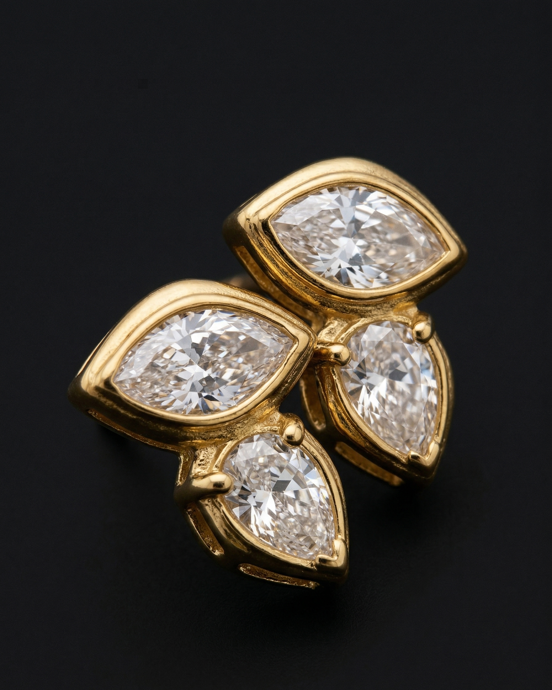 Gold earrings with pear-shaped diamonds on a black background