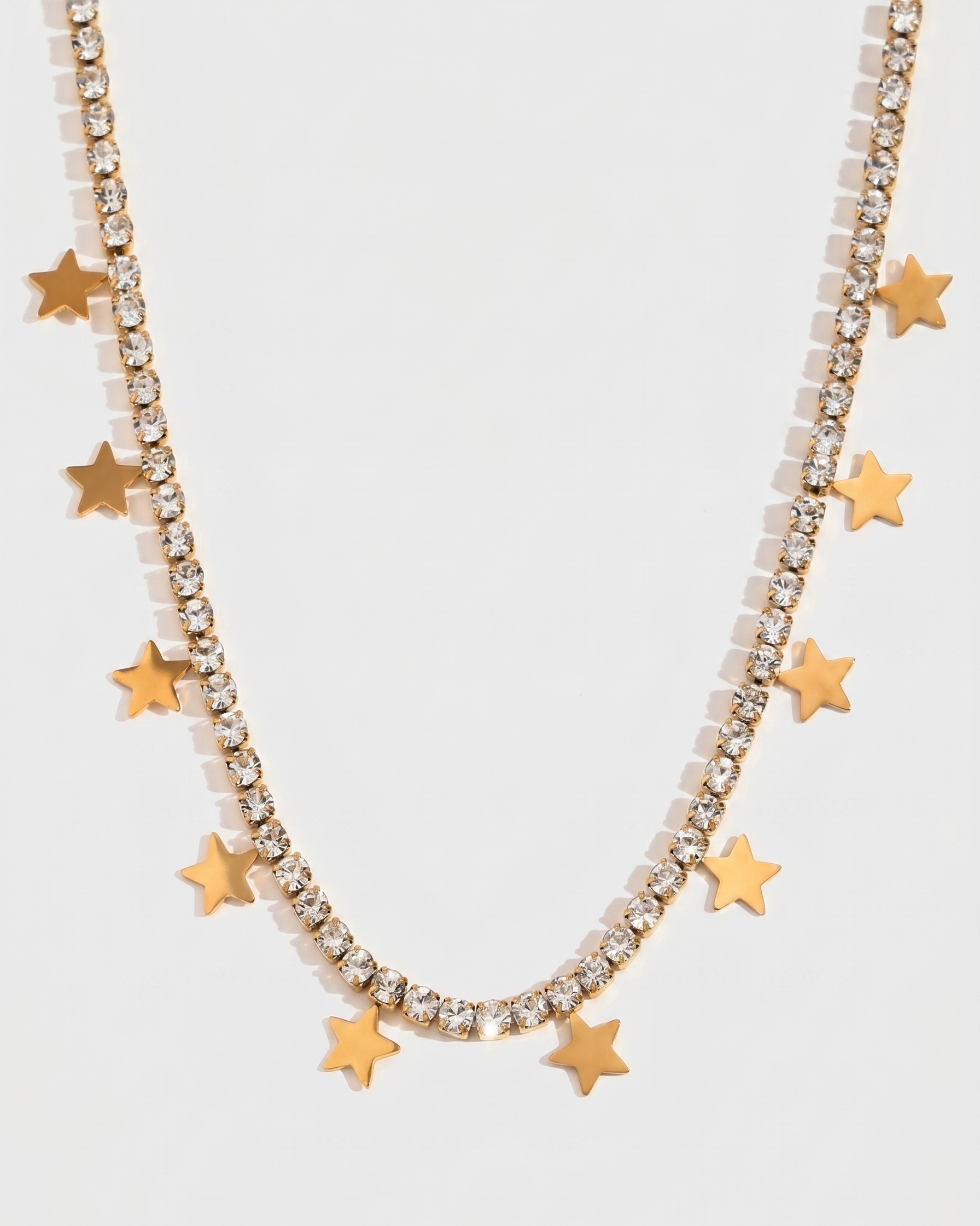 Necklace with gold star pendants on a light gray background