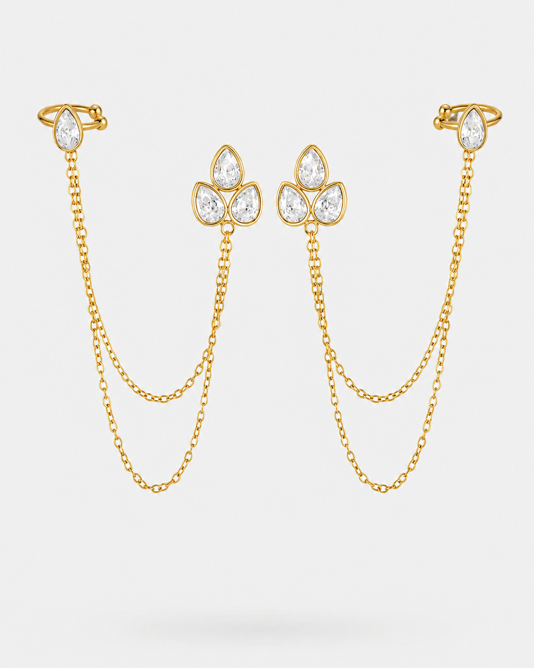 Gold-toned double chain ear cuffs with pear-cut clear gemstone clusters at the top and ear posts, displayed on a light gray background.