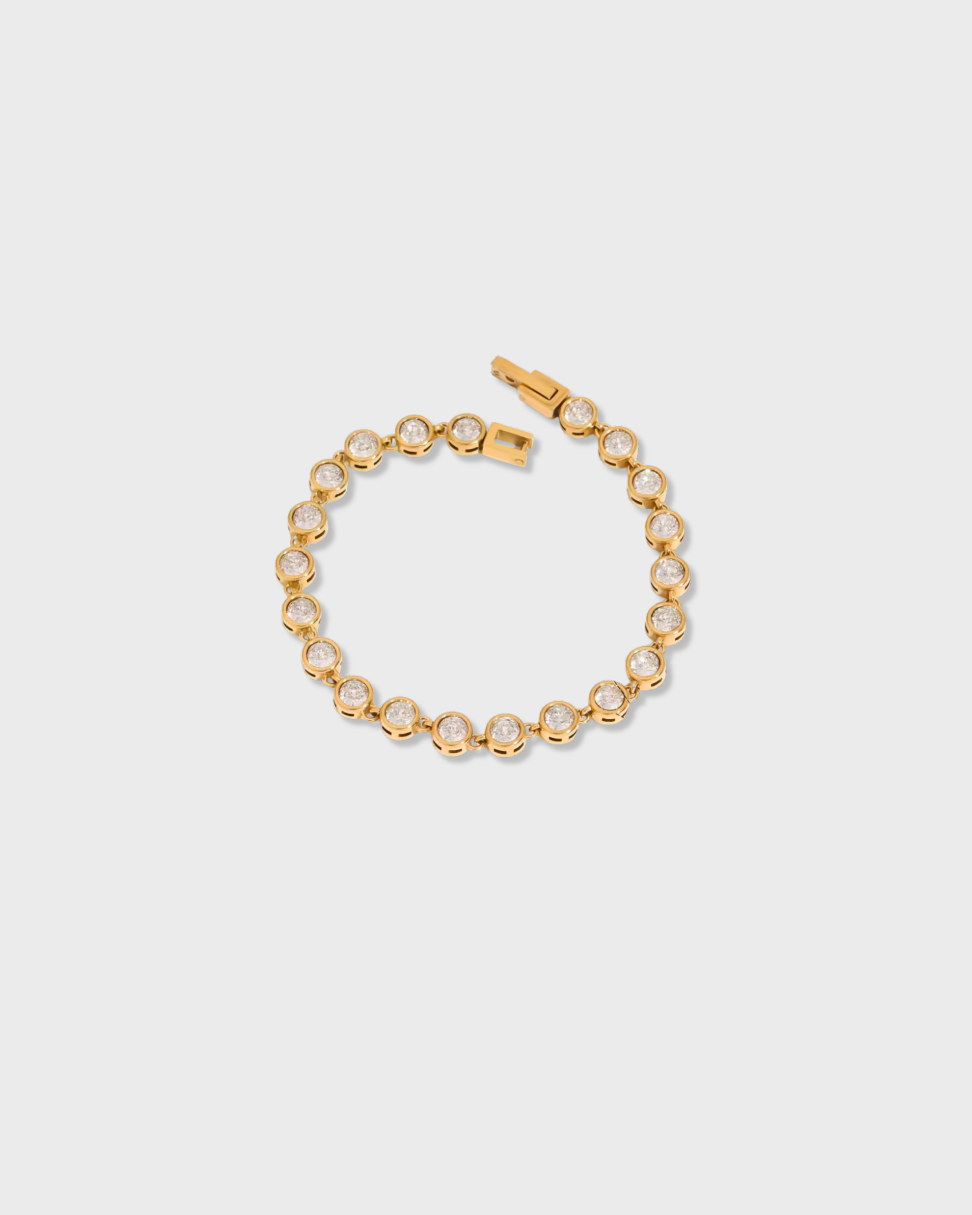 Gold bracelet with clear stones on a light gray background