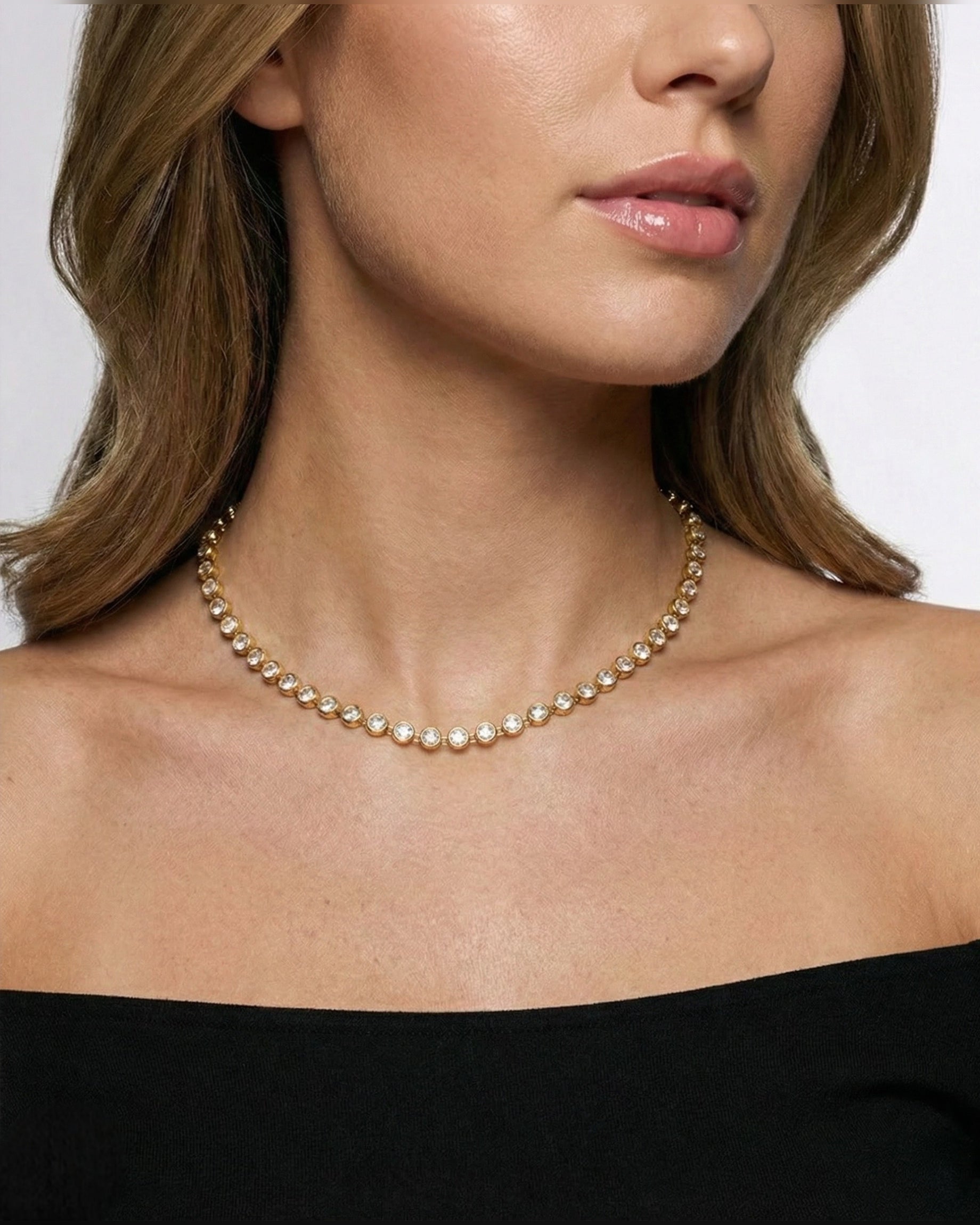 Woman wearing a gold necklace against a neutral background