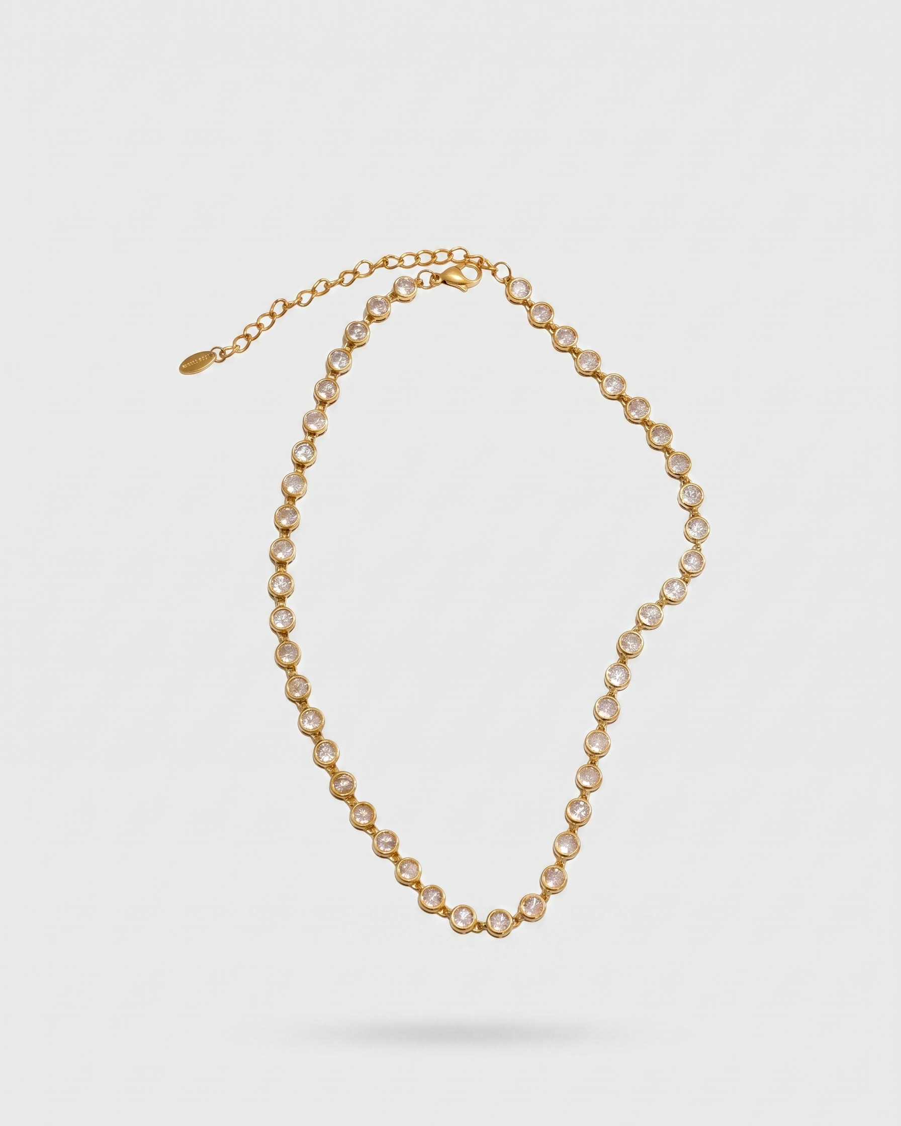 Gold necklace with pearls on a light gray background