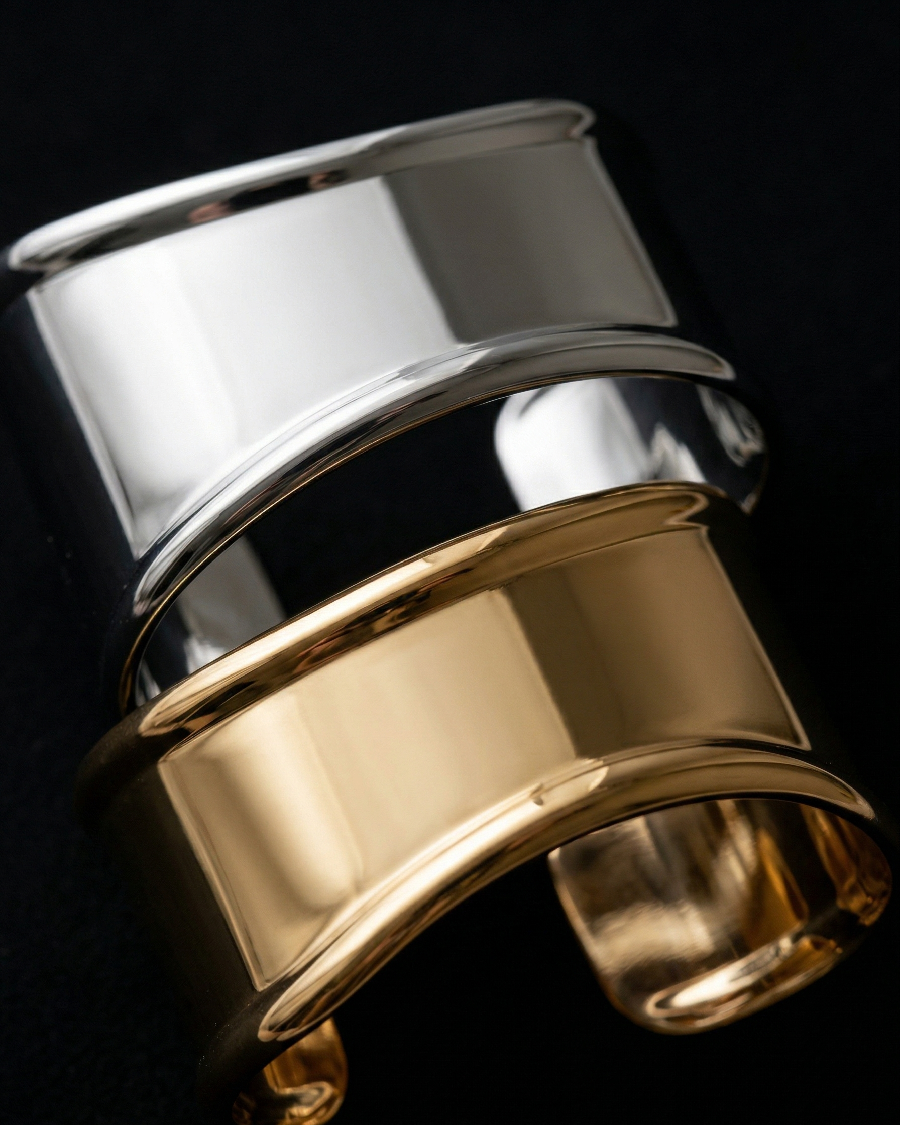 Gold and silver cuff bracelet on a black background