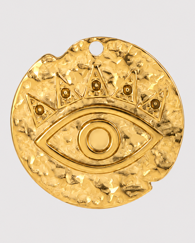 A textured gold pendant featuring an all-seeing eye and a crown motif, shown against a light gray background with a soft shadow underneath.