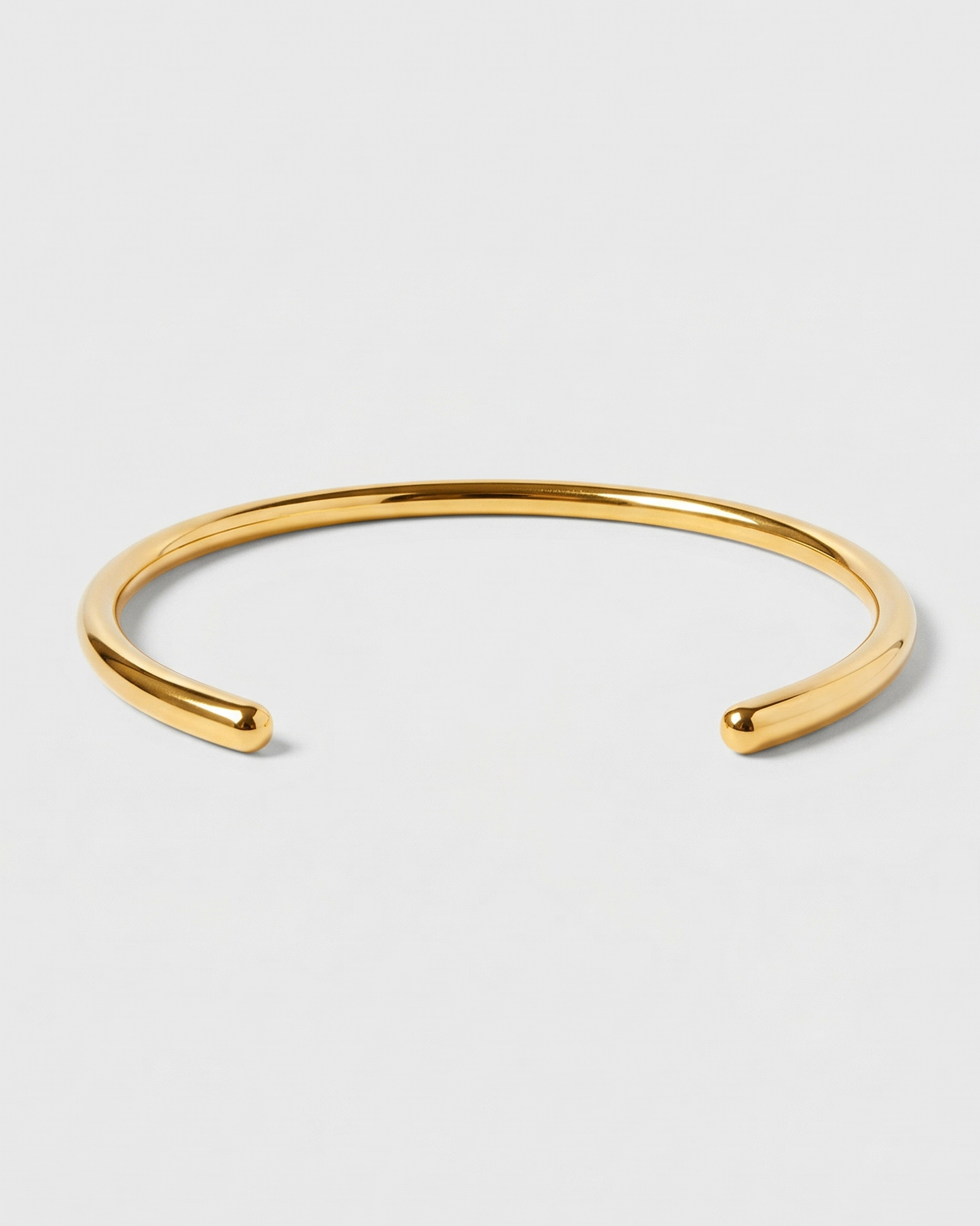Gold bracelet on a light gray background