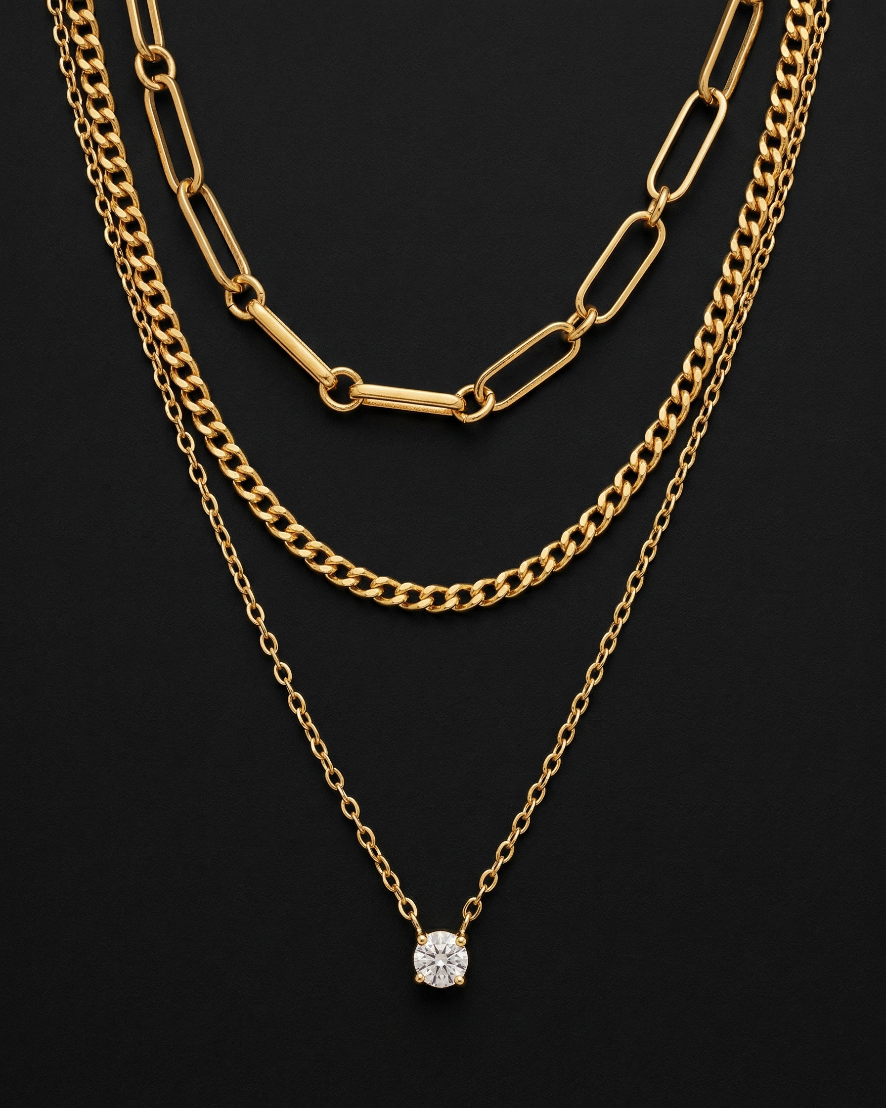 Two gold chain necklaces on a black background