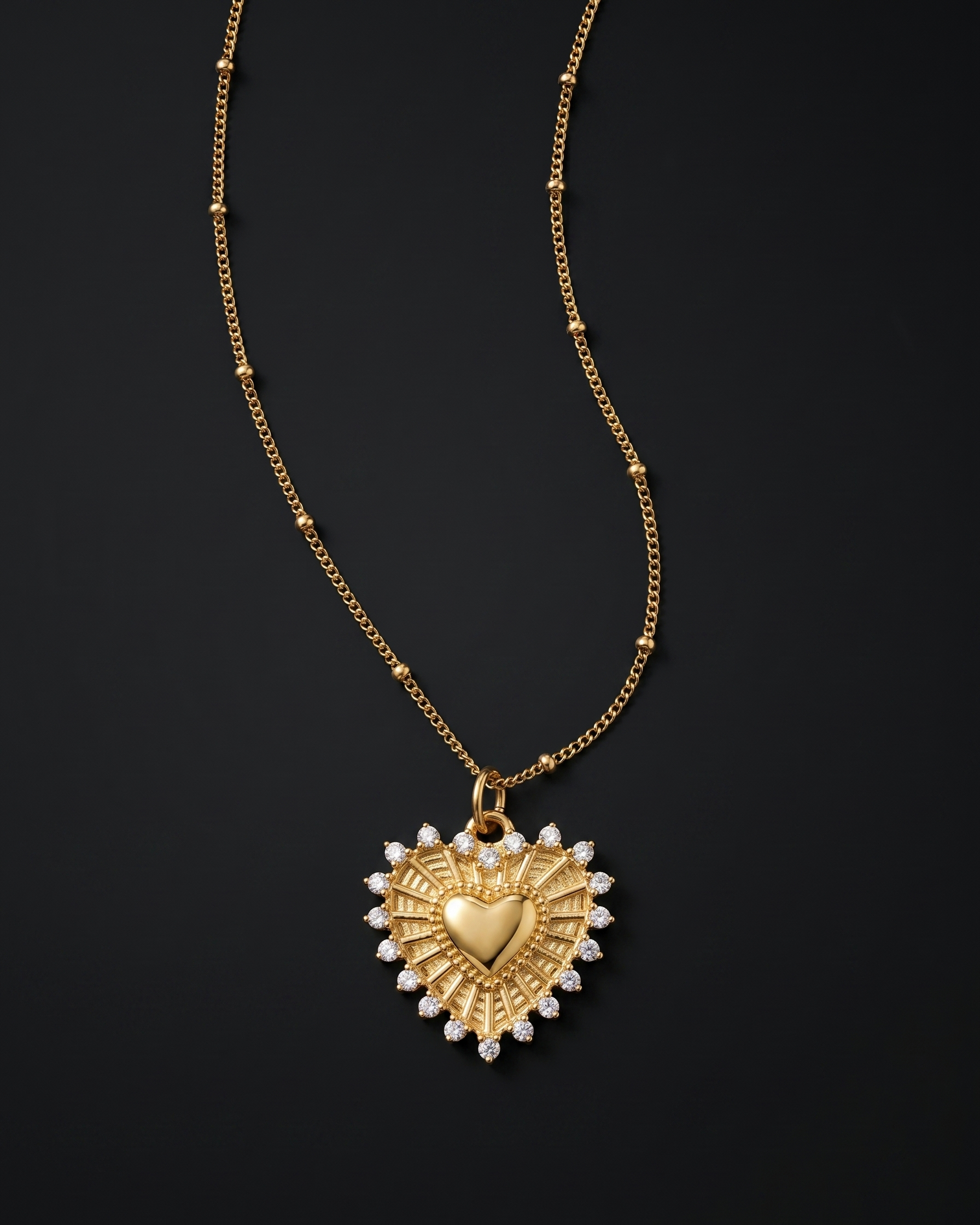 Gold heart-shaped pendant necklace with pearls on a black background