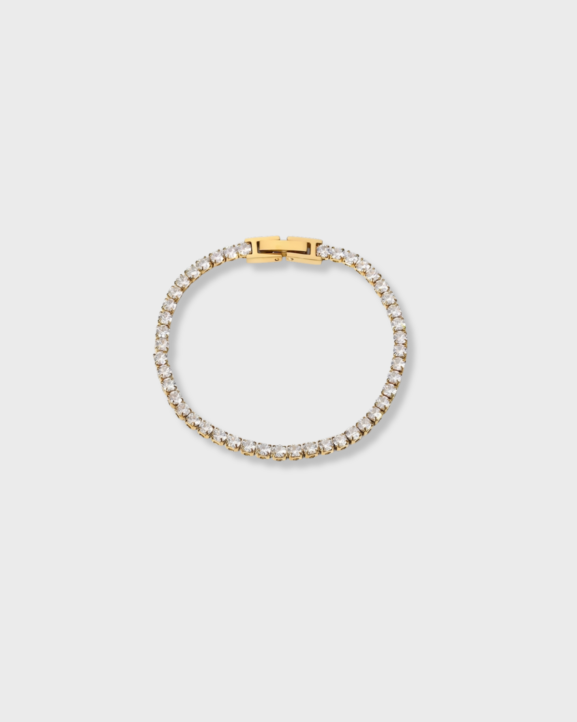 Gold bracelet with clear stones on a light gray background