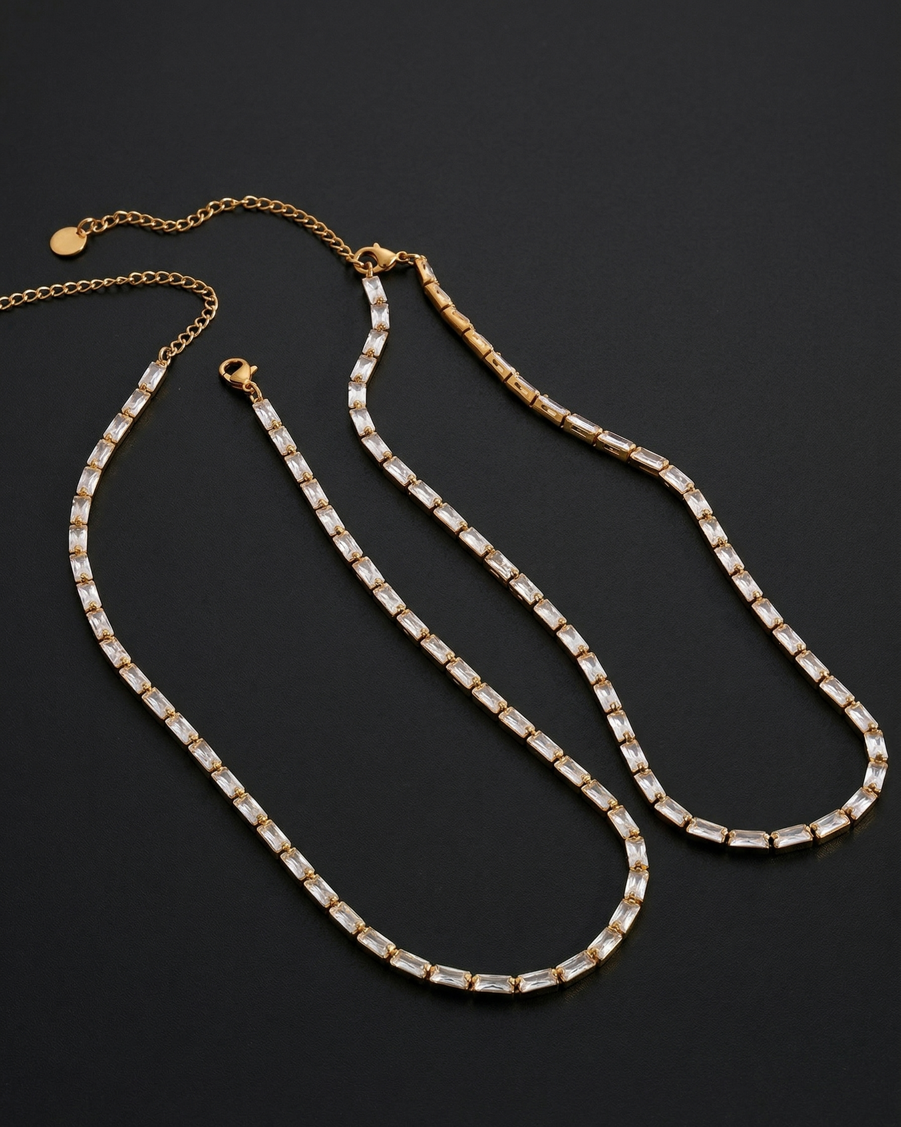Gold and silver chain necklaces on a dark background