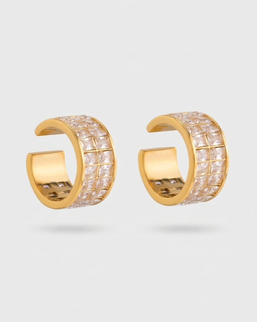 Gold hoop earrings with embedded stones on a light gray background