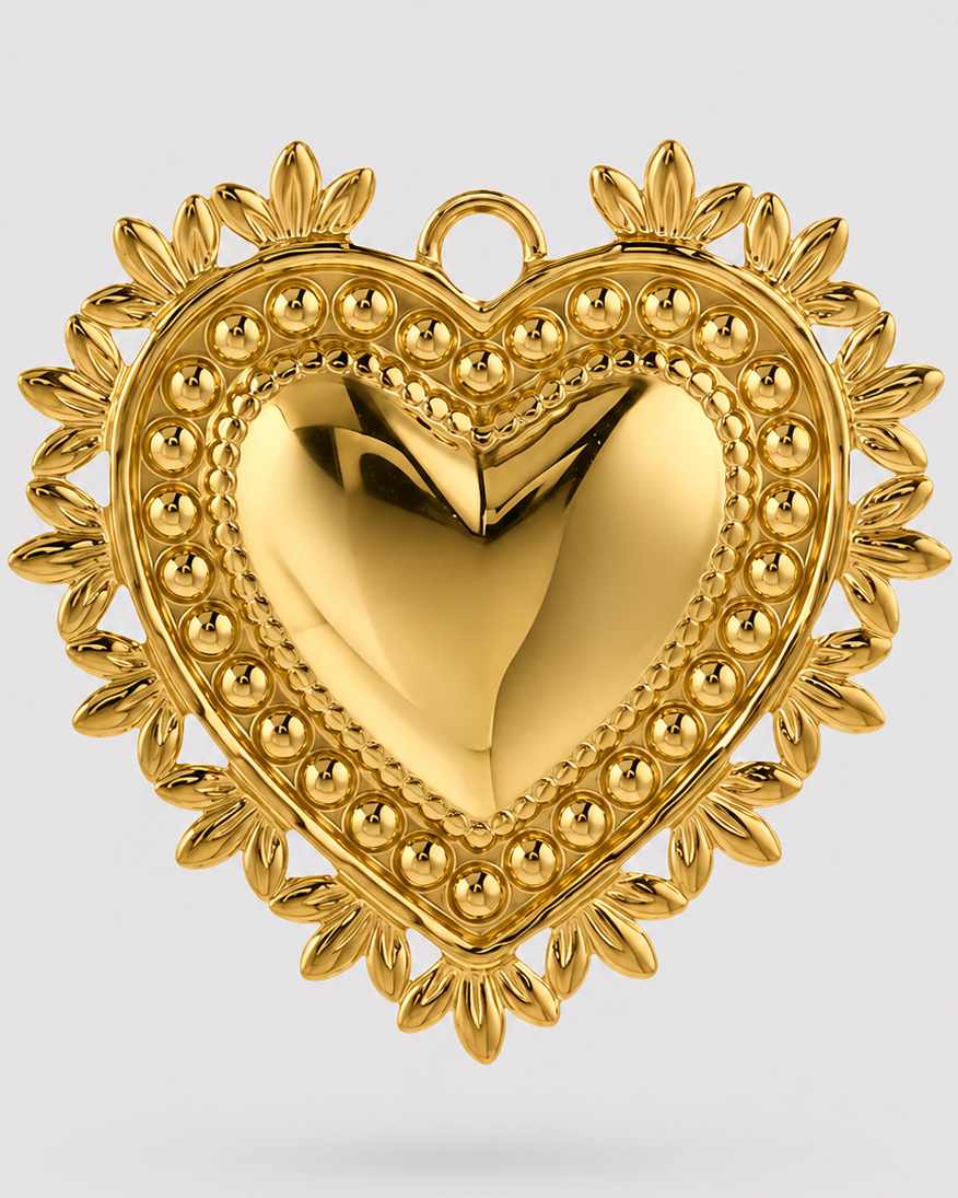 A polished gold heart-shaped pendant with a raised central heart, beaded border, and leaf-like rays around the edge, shown on a light gray background.