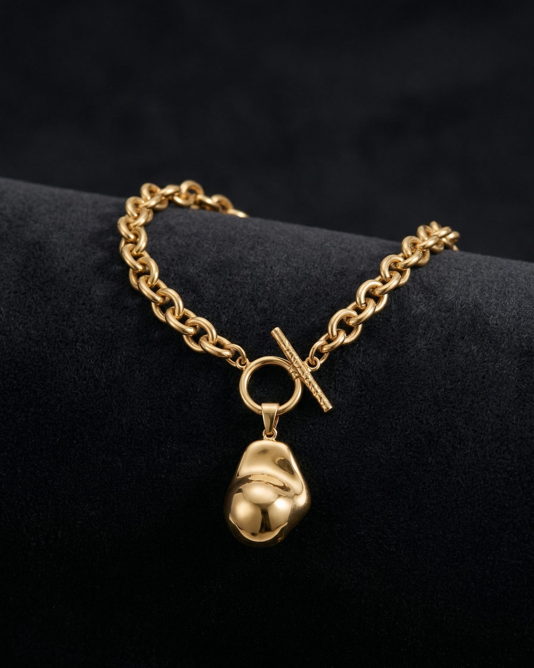 Gold chain bracelet with a unique pendant on a black background