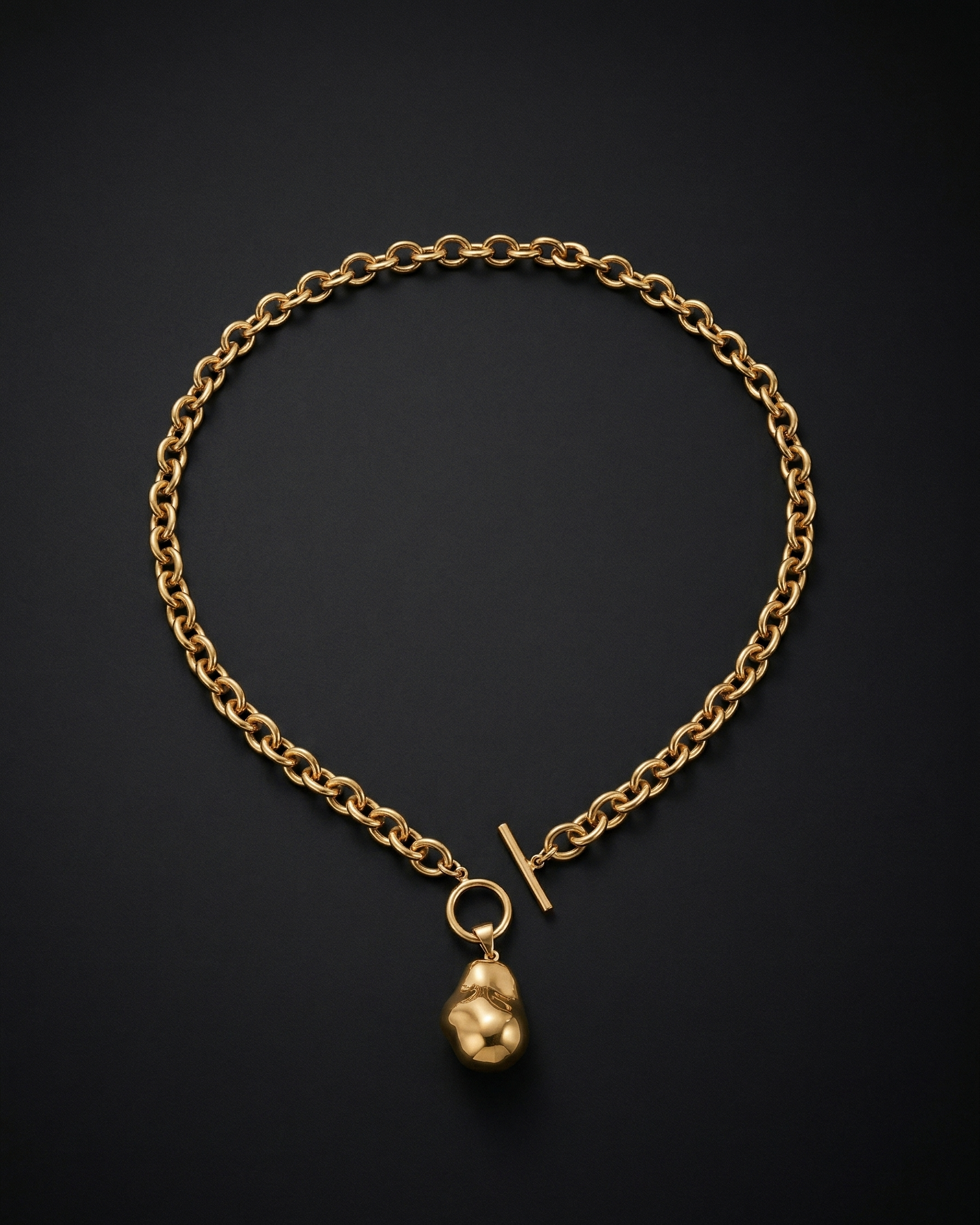 Gold chain bracelet with a small gold pendant on a black background