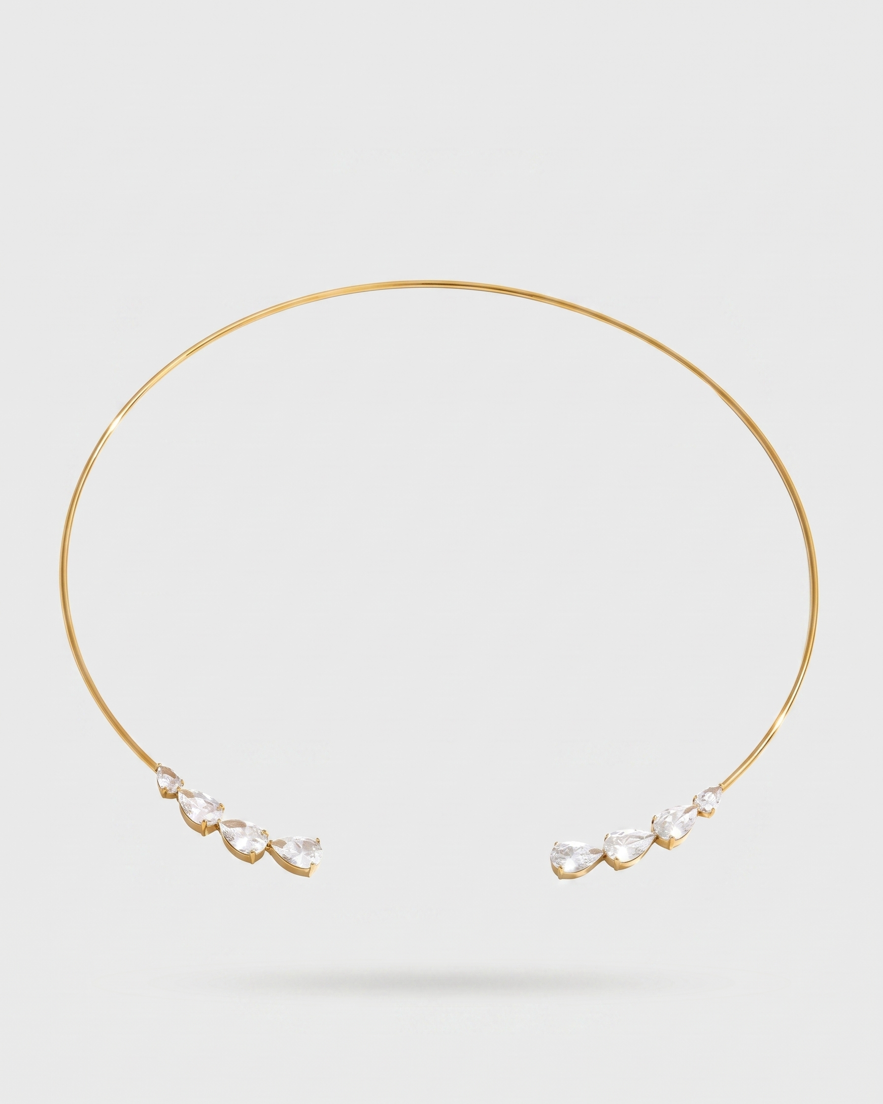 Gold necklace with pearl-like pendants on a light gray background