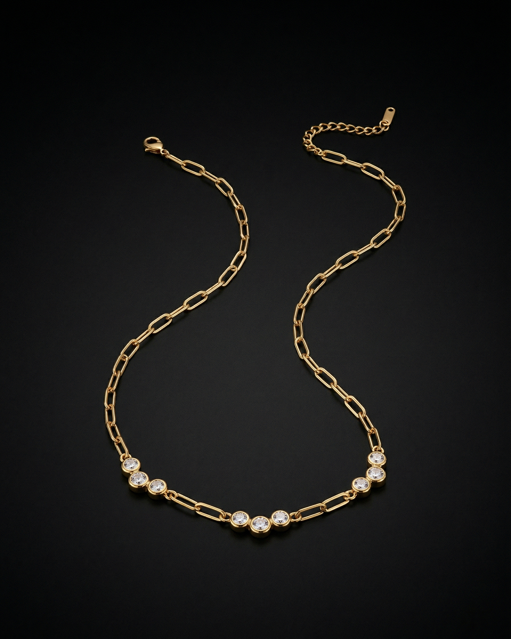 Gold chain necklace with small diamonds on a black background