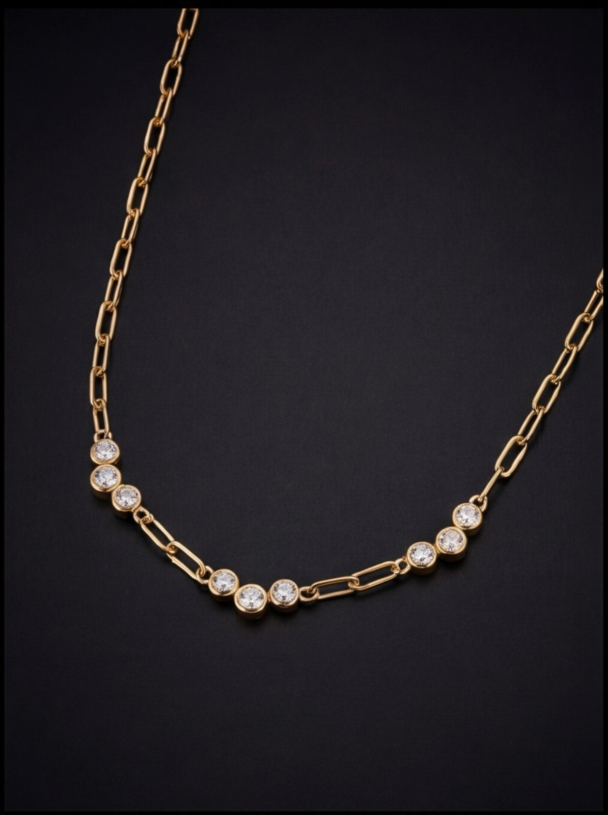 Gold necklace with diamond-like beads on a black background