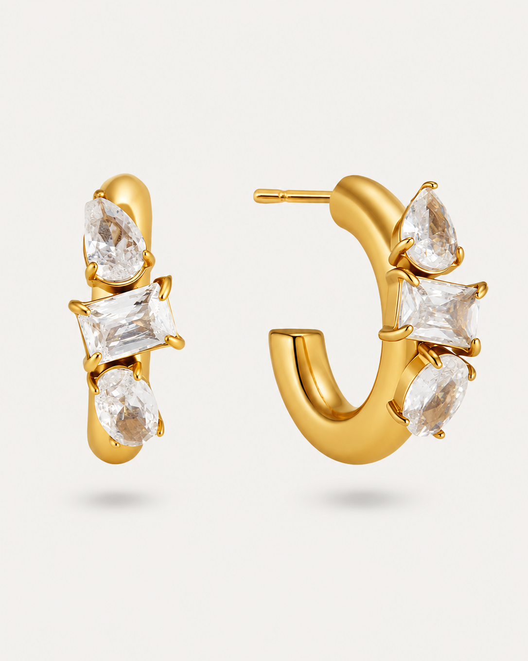 Gold hoop earrings with a cluster of clear marquise and rectangular gemstones, shown on a light gray background.