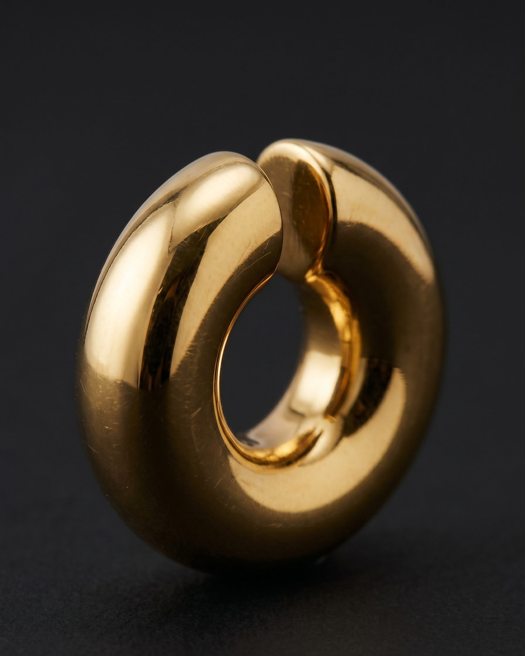 Gold ring with a unique design on a black background