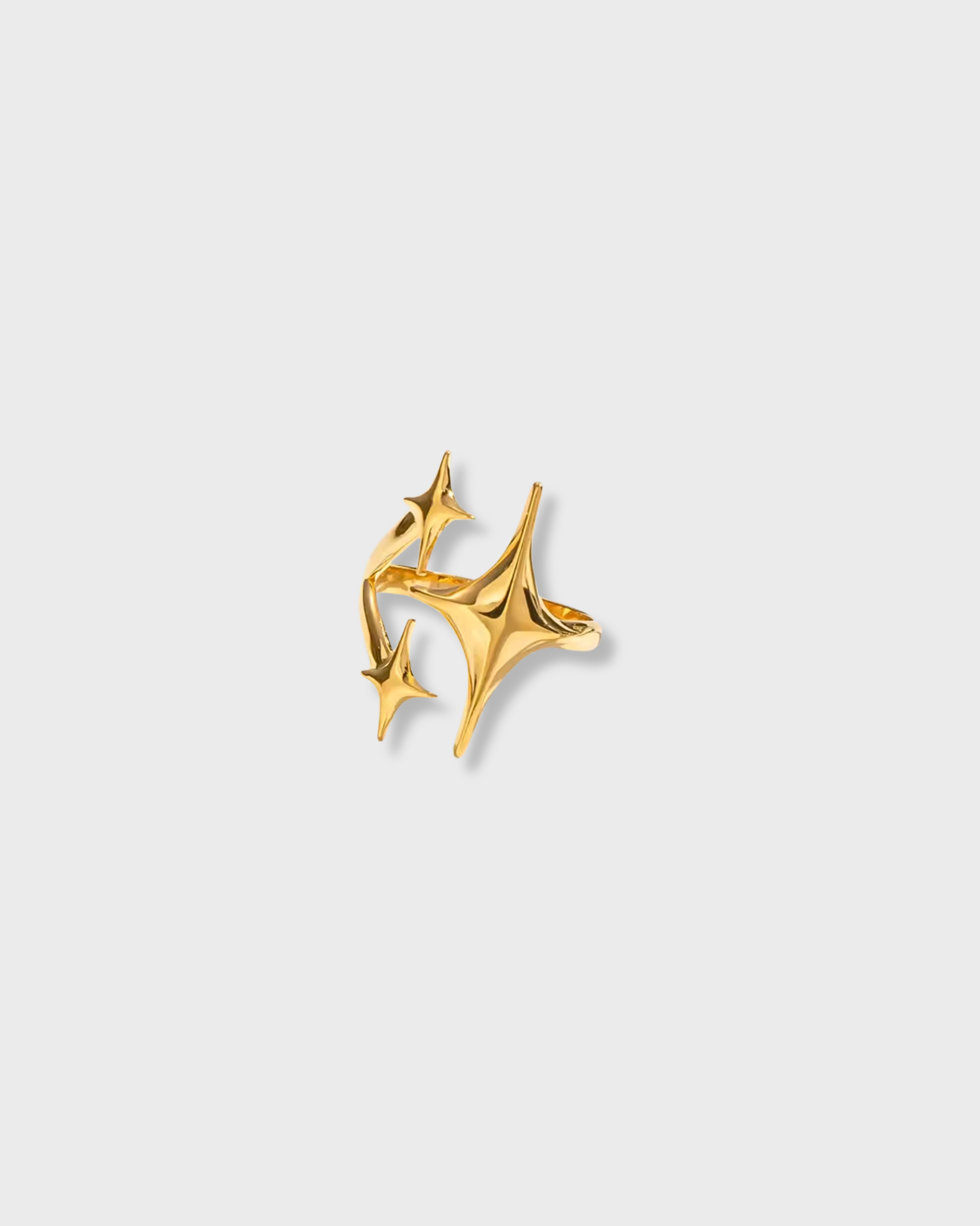 Gold earring with star design on a light gray background