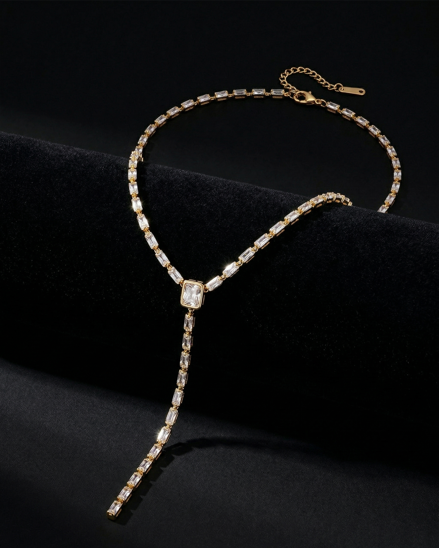 Delicate gold necklace with a central gemstone on a black background