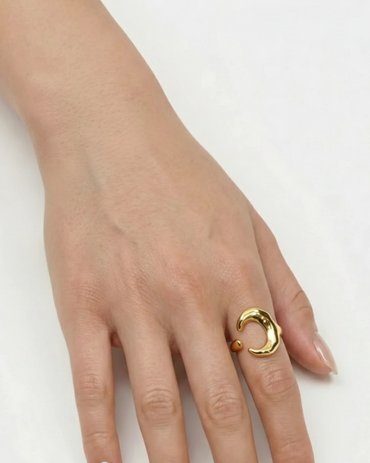 Hand wearing a gold ring on a white background