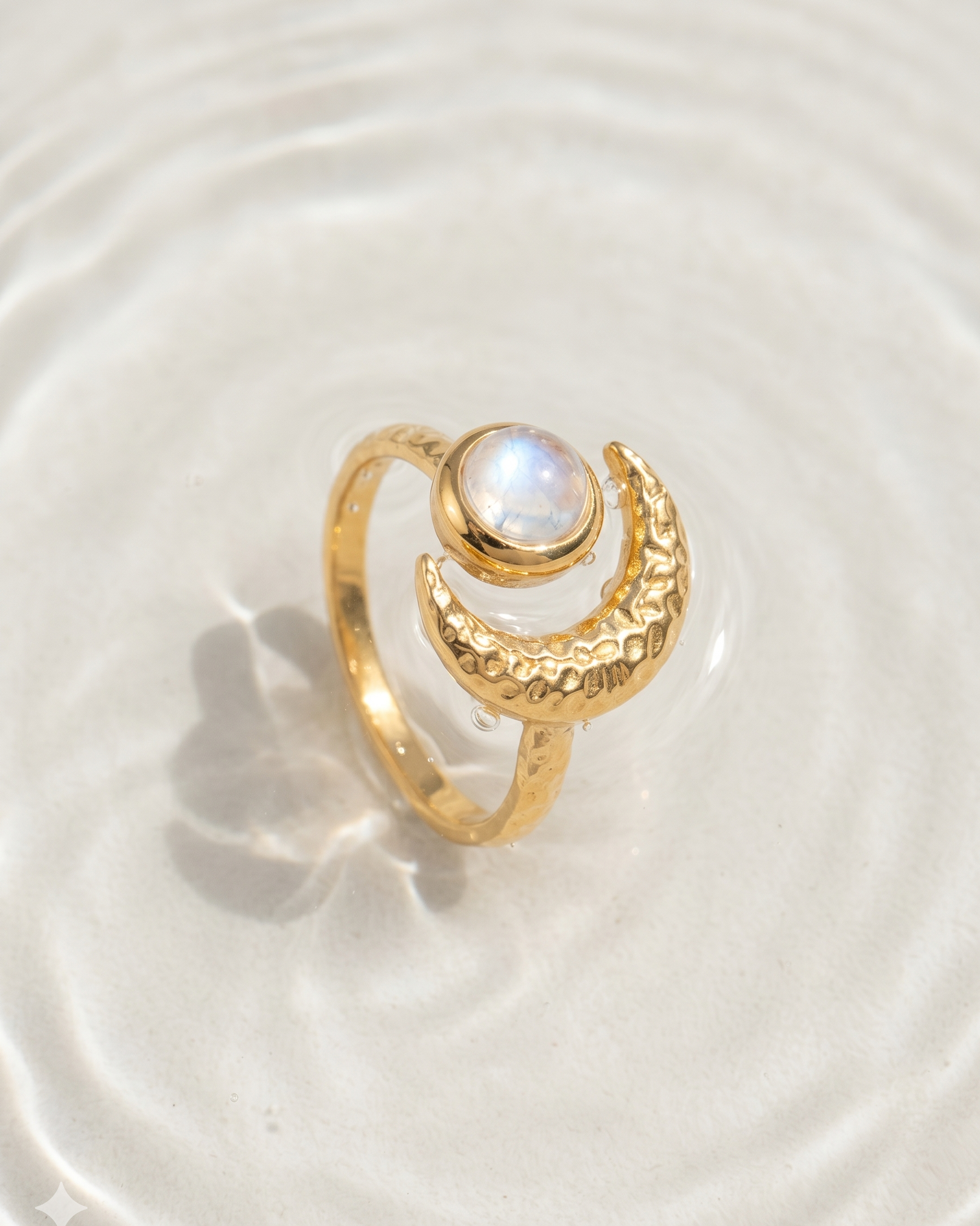 Gold ring with a moonstone on a white background