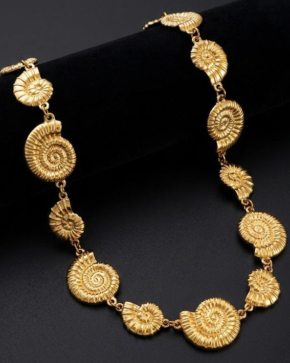 Gold necklace with intricate designs on a black background