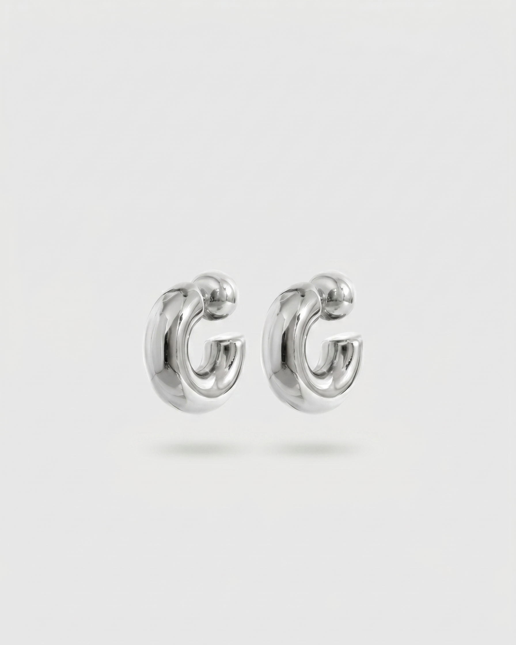 Pair of silver hoop earrings on a light gray background