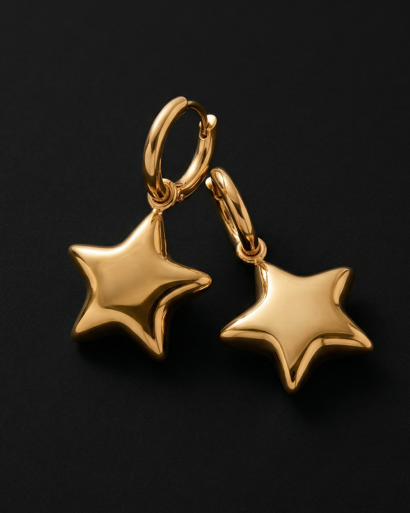 Gold star-shaped earrings on a black background