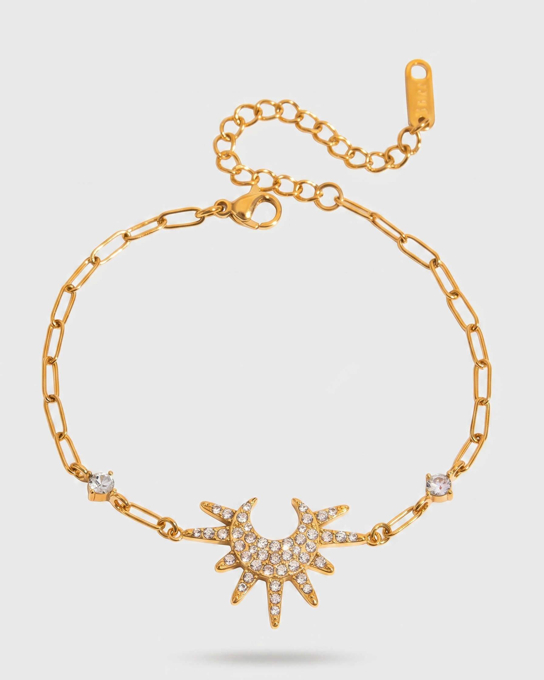 Gold bracelet with star-shaped clasp on a light gray background