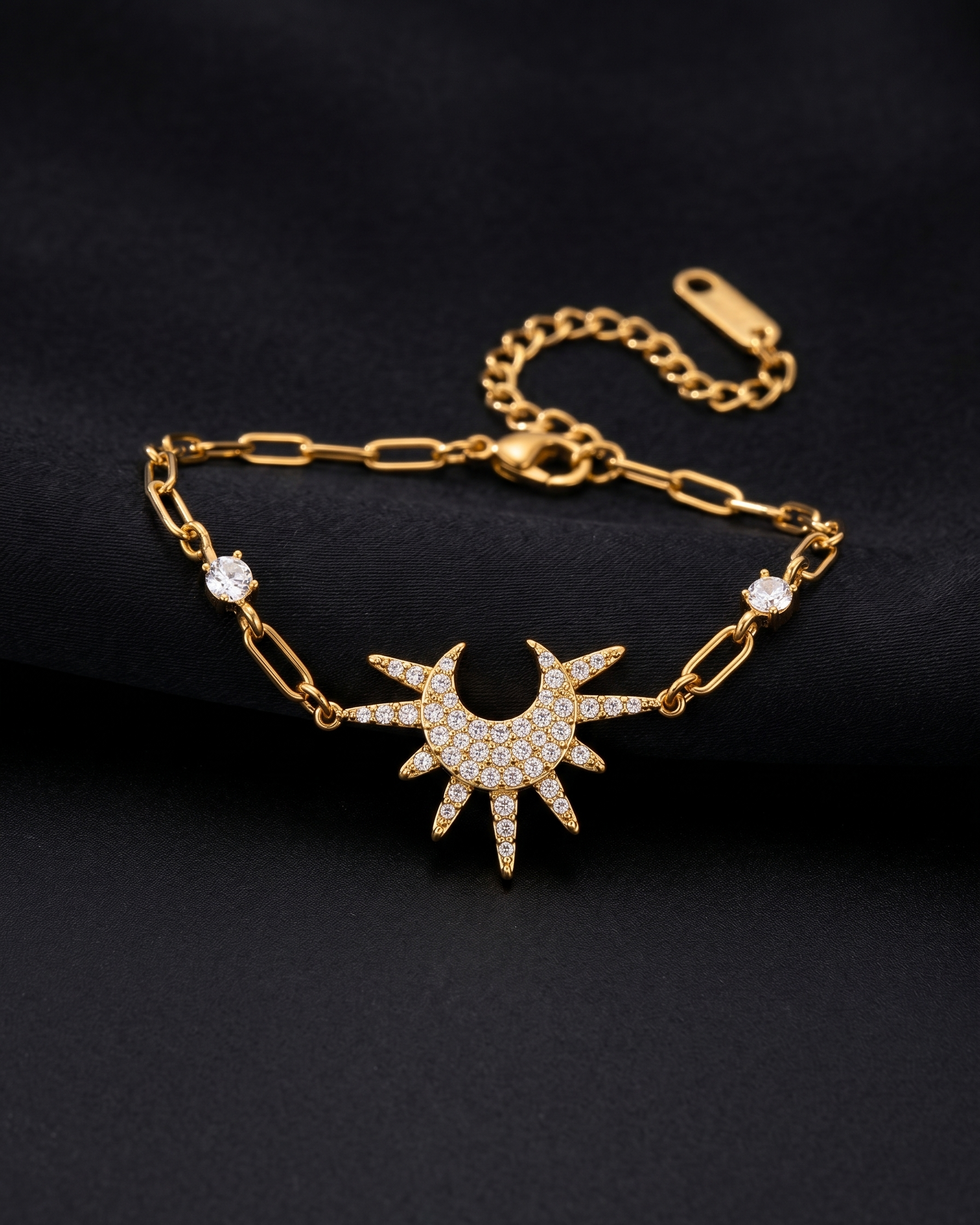 Gold bracelet with sun design and small diamonds on a black background