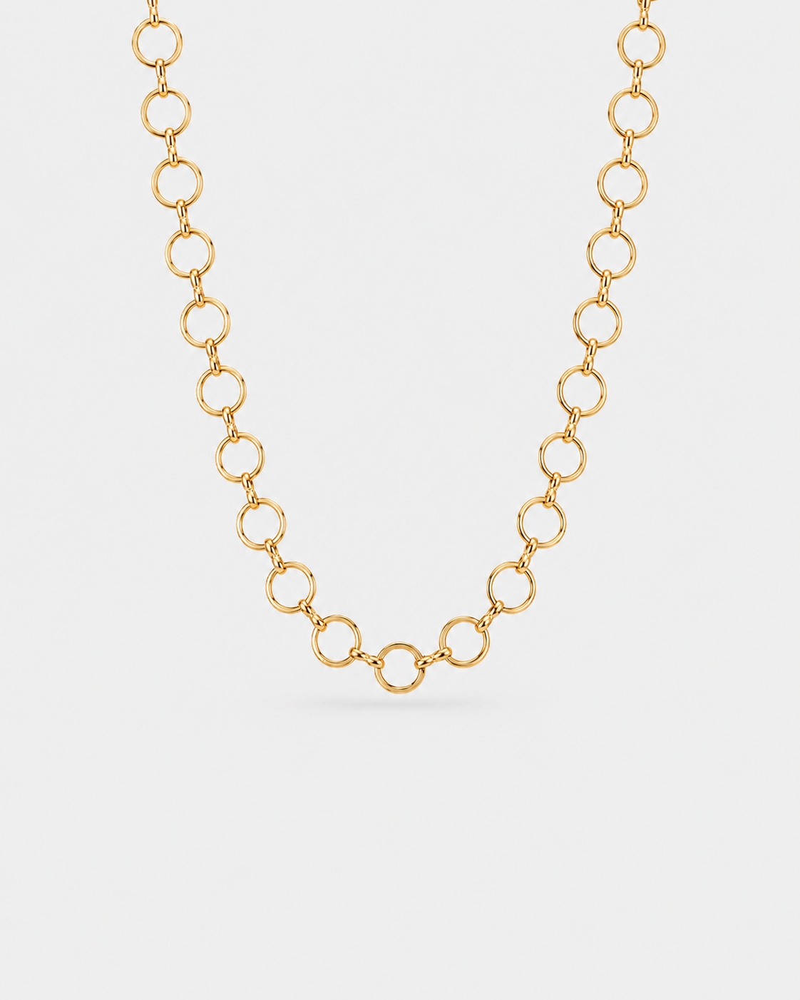 A gold chain necklace featuring a series of interlocking open circular links, displayed against a clean, light gray background.
