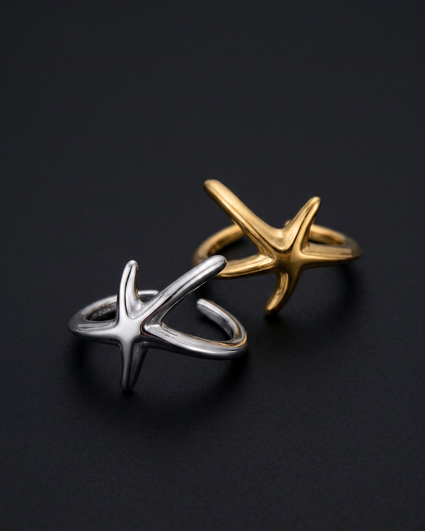 Gold and silver star-shaped rings on a black background