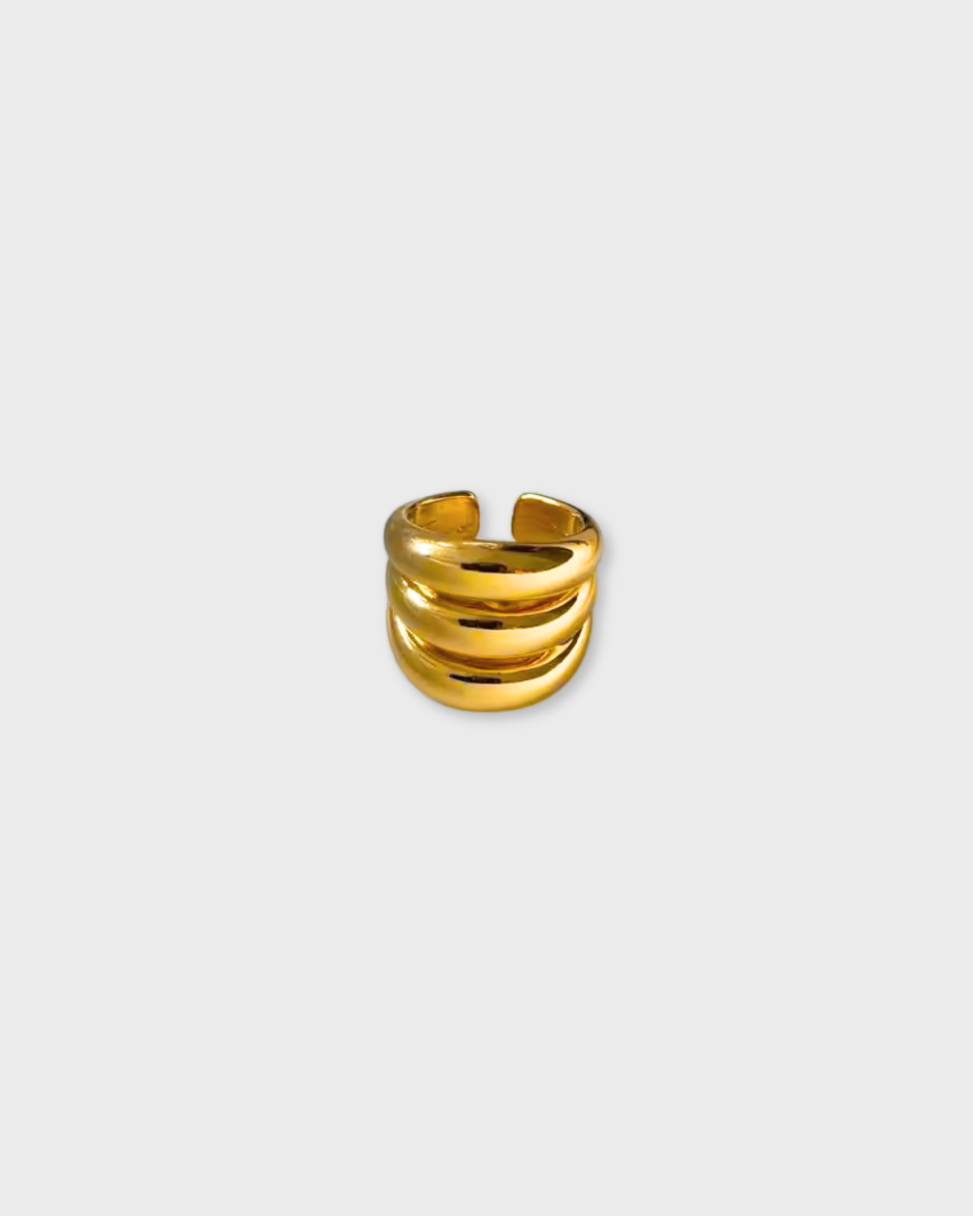 Gold ring with three horizontal bands on a light gray background