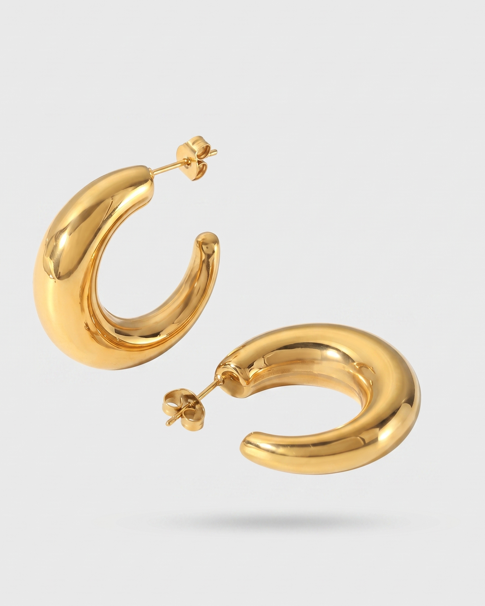 Gold hoop earrings on a light gray background
