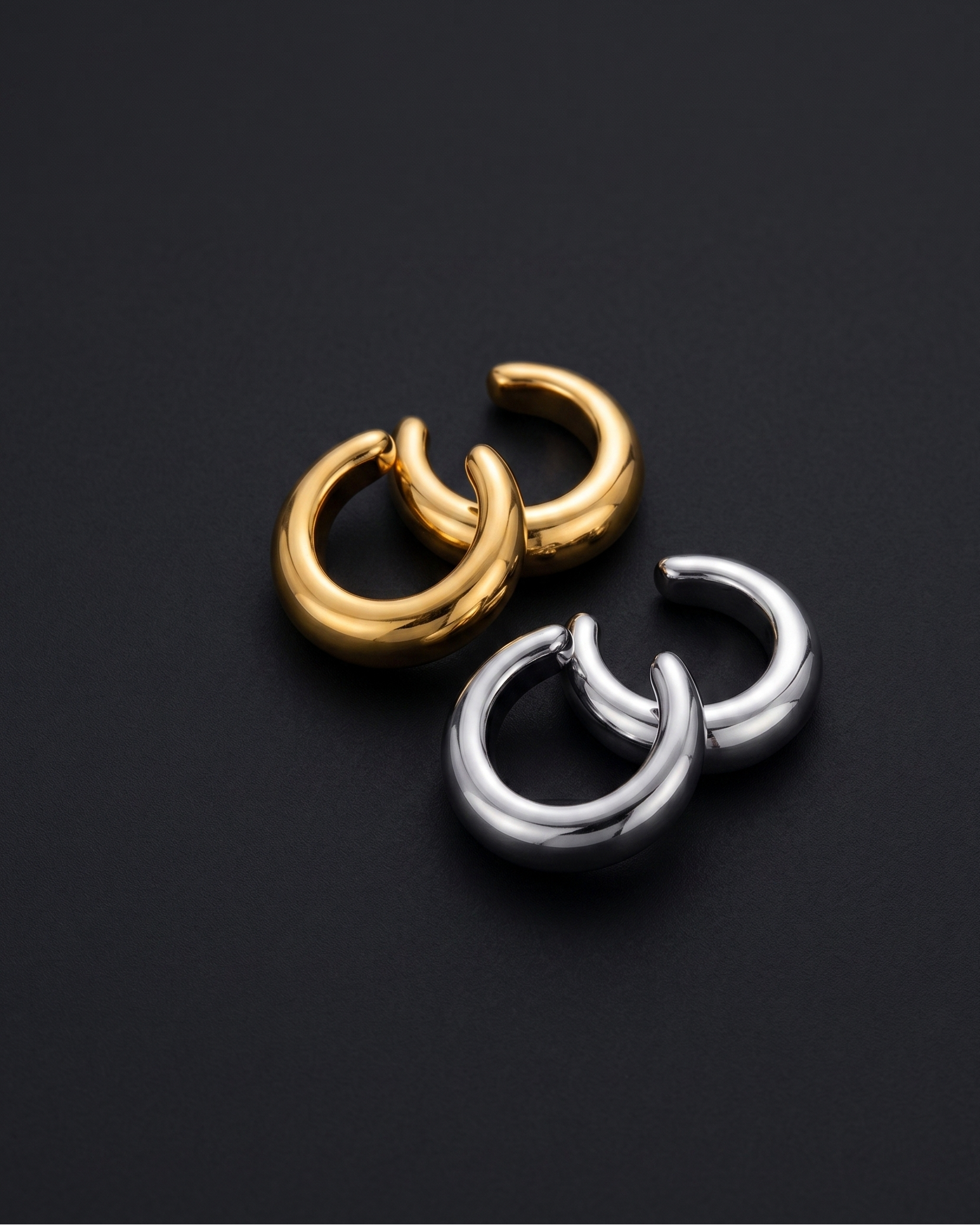 Gold and silver hoop earrings on a black background
