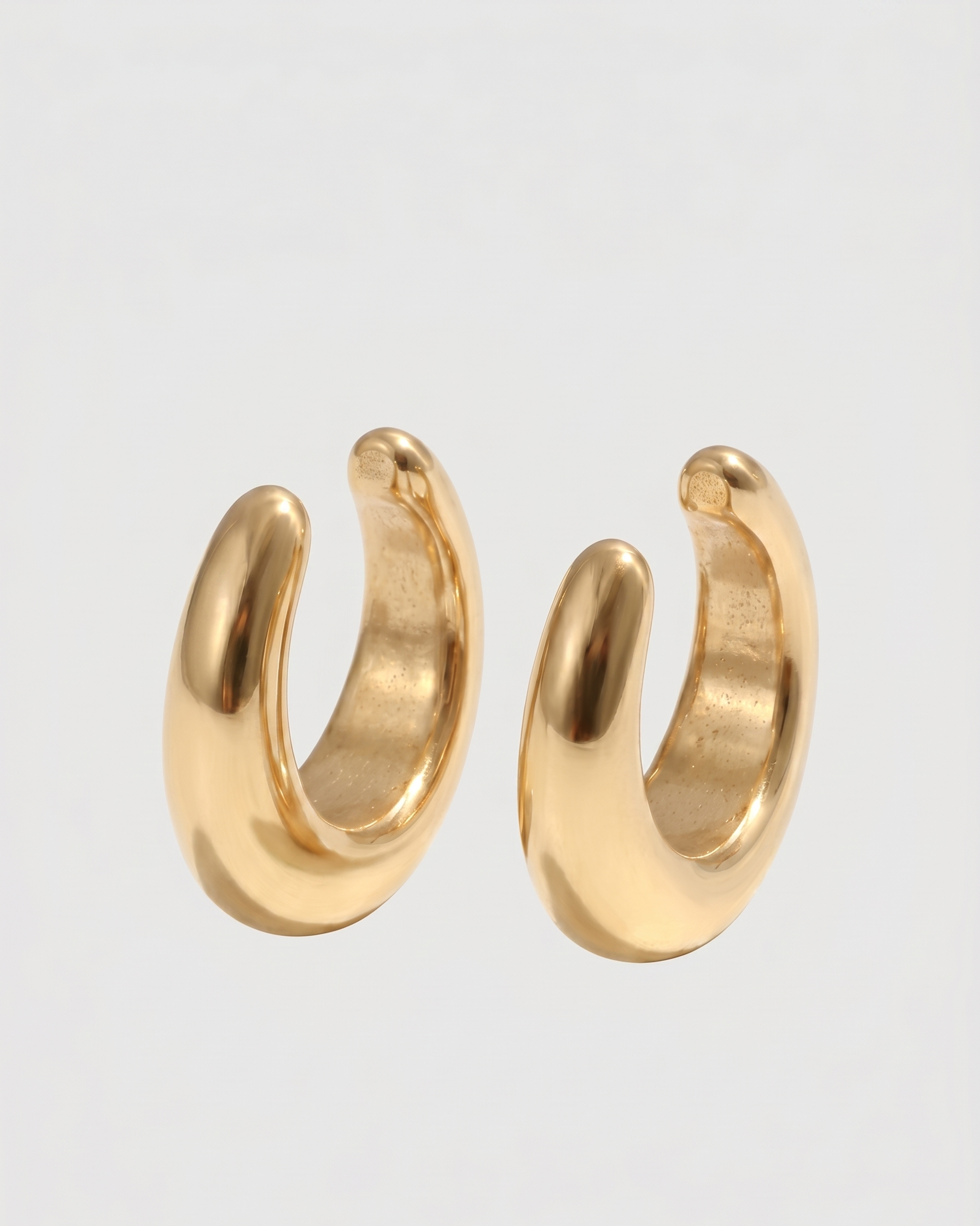 Pair of gold hoop earrings on a light gray background