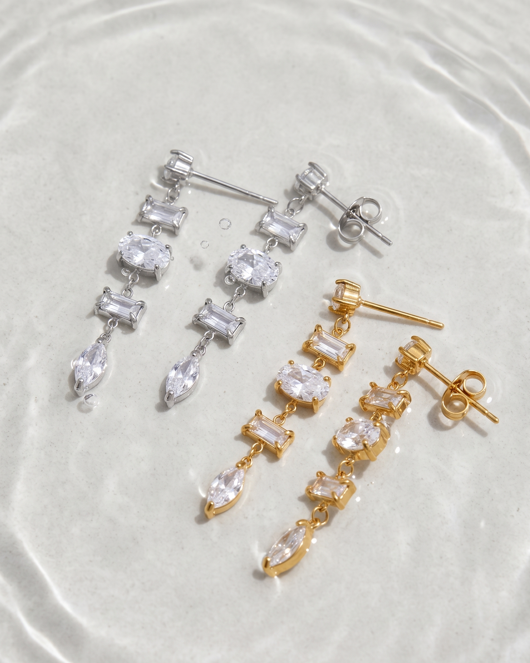 Pair of gold and silver earrings on a white background