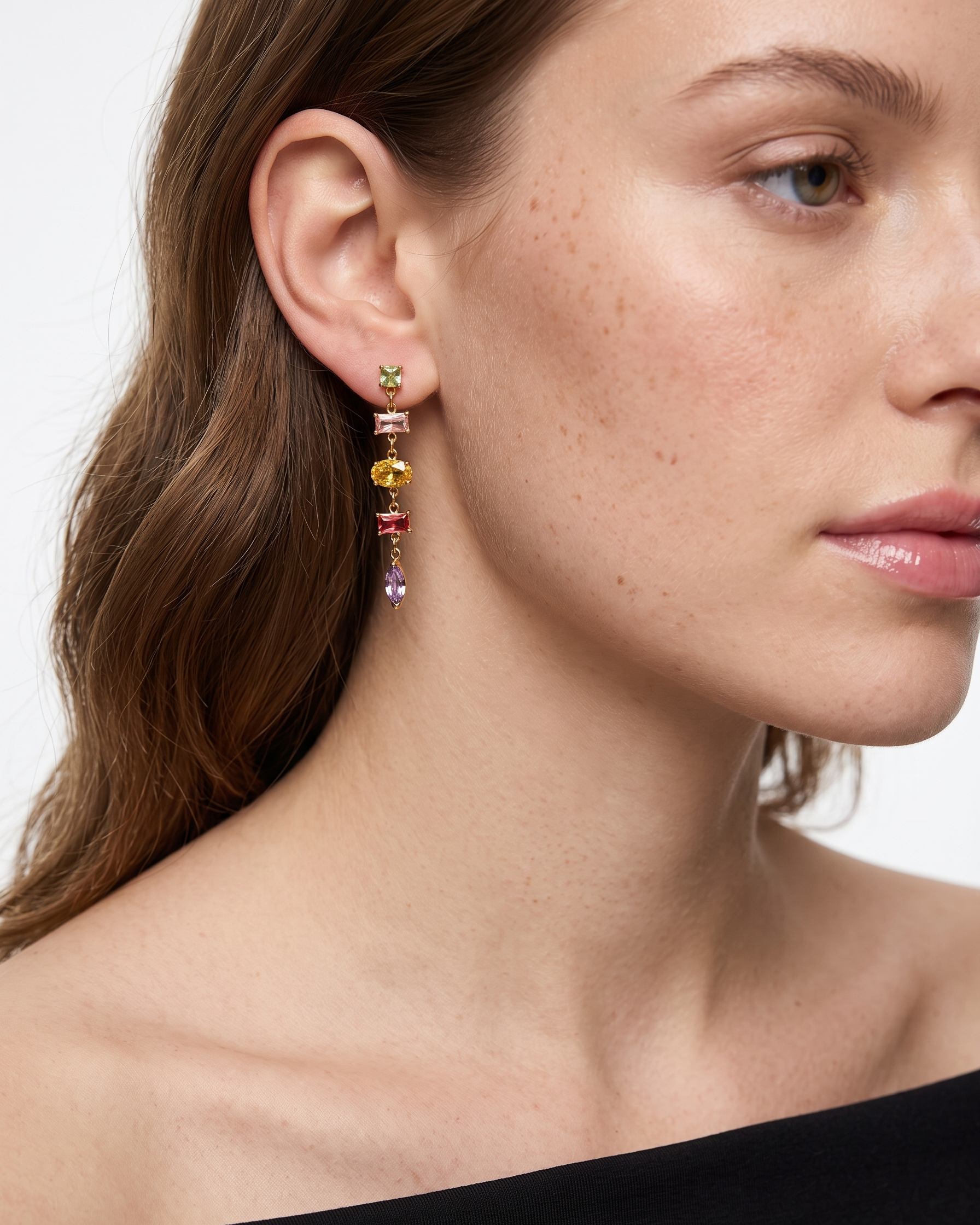 Close-up of a woman wearing colorful earrings with a neutral background