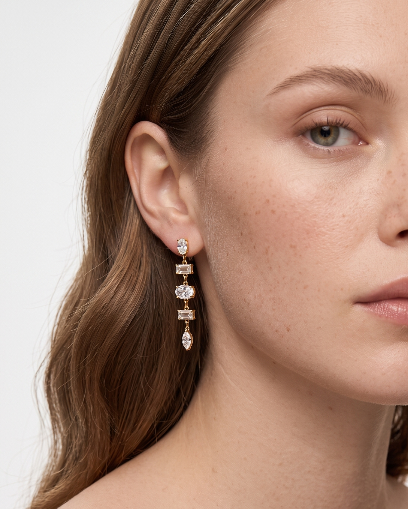 Woman wearing elegant earrings with a neutral background