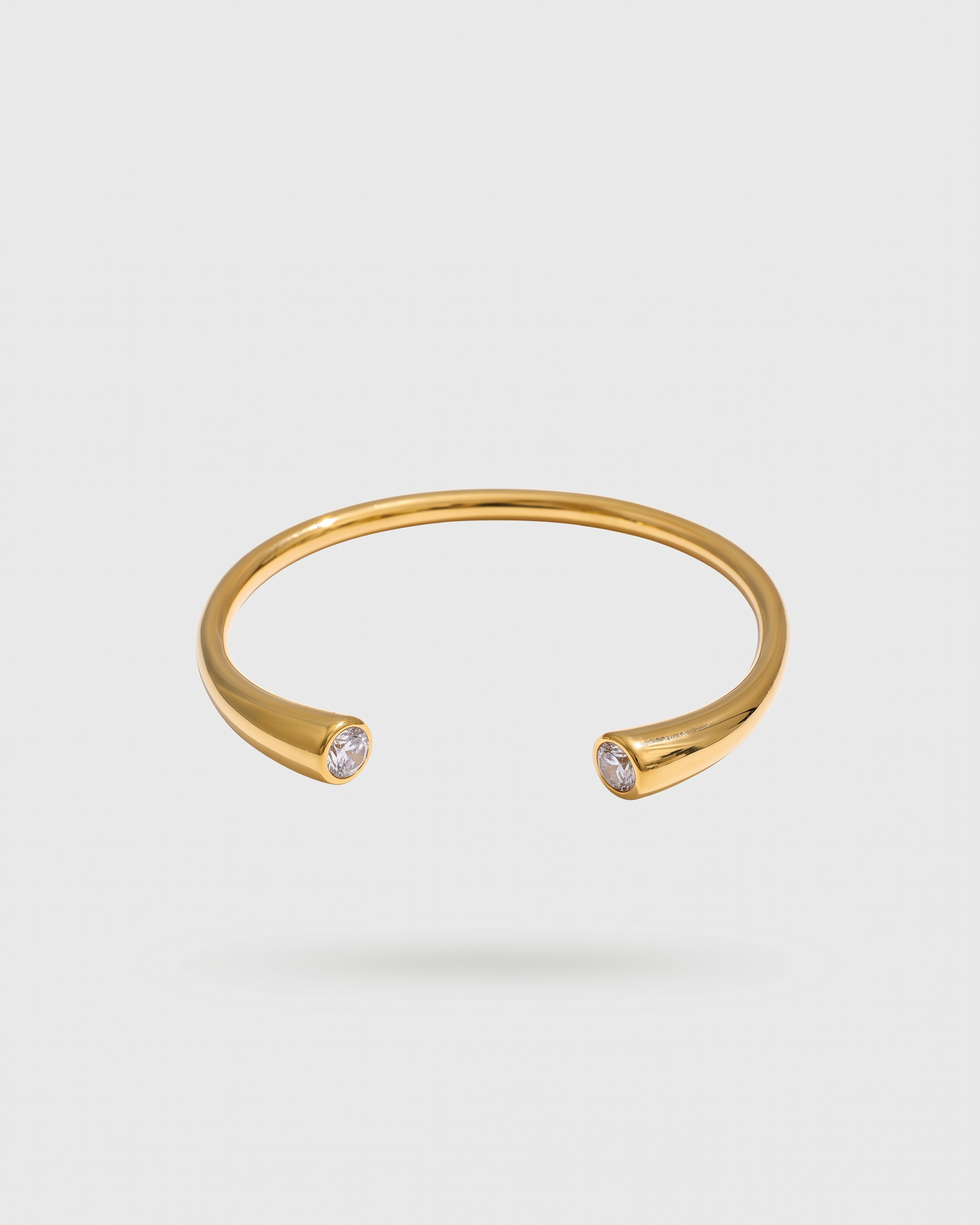 Gold bracelet with small crystals on a white background